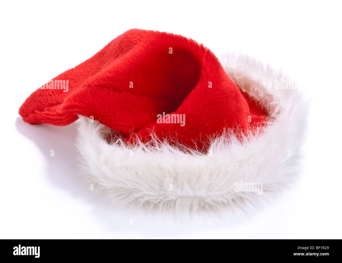 Fluffy red and white santa hat isolated against white background. Stock Photo