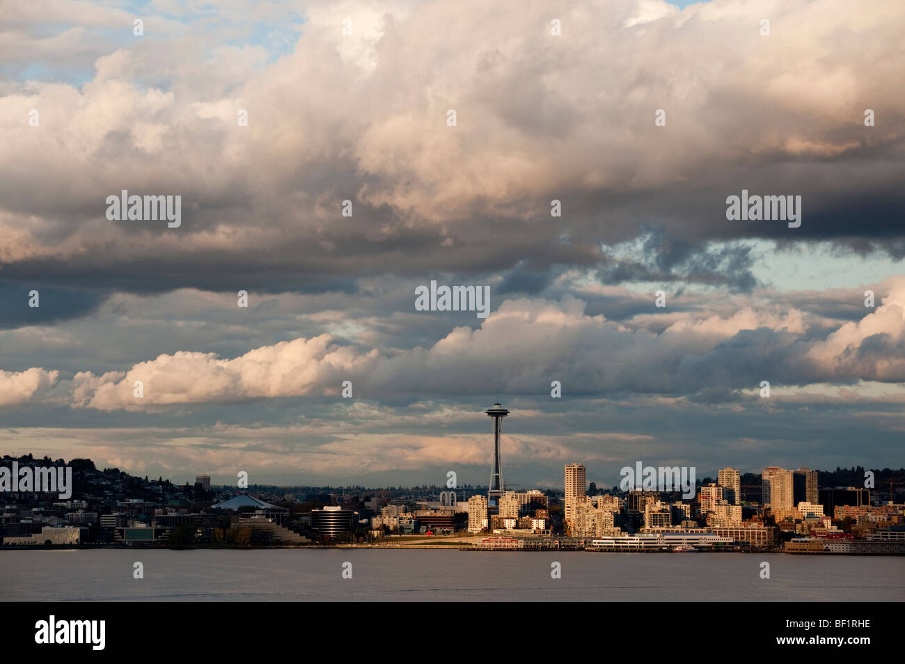 A dramatic sunset view of the Seattle, Washington skyline in Puget Sound and the Elliott Bay waterfront. Stock Photo