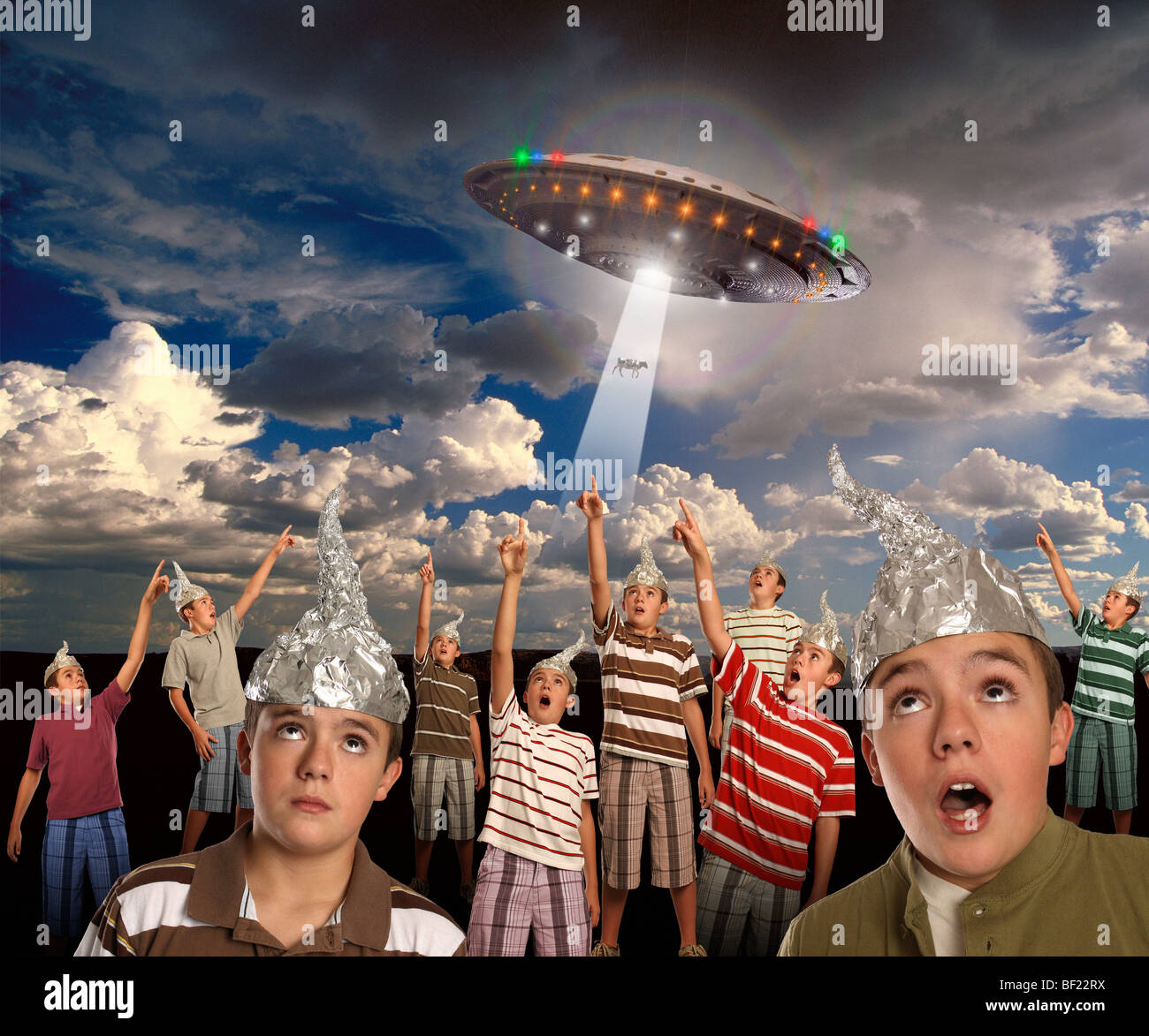 A group of CLONES wearing tin-foil hats points to a UFO abducting a COW! Stock Photo