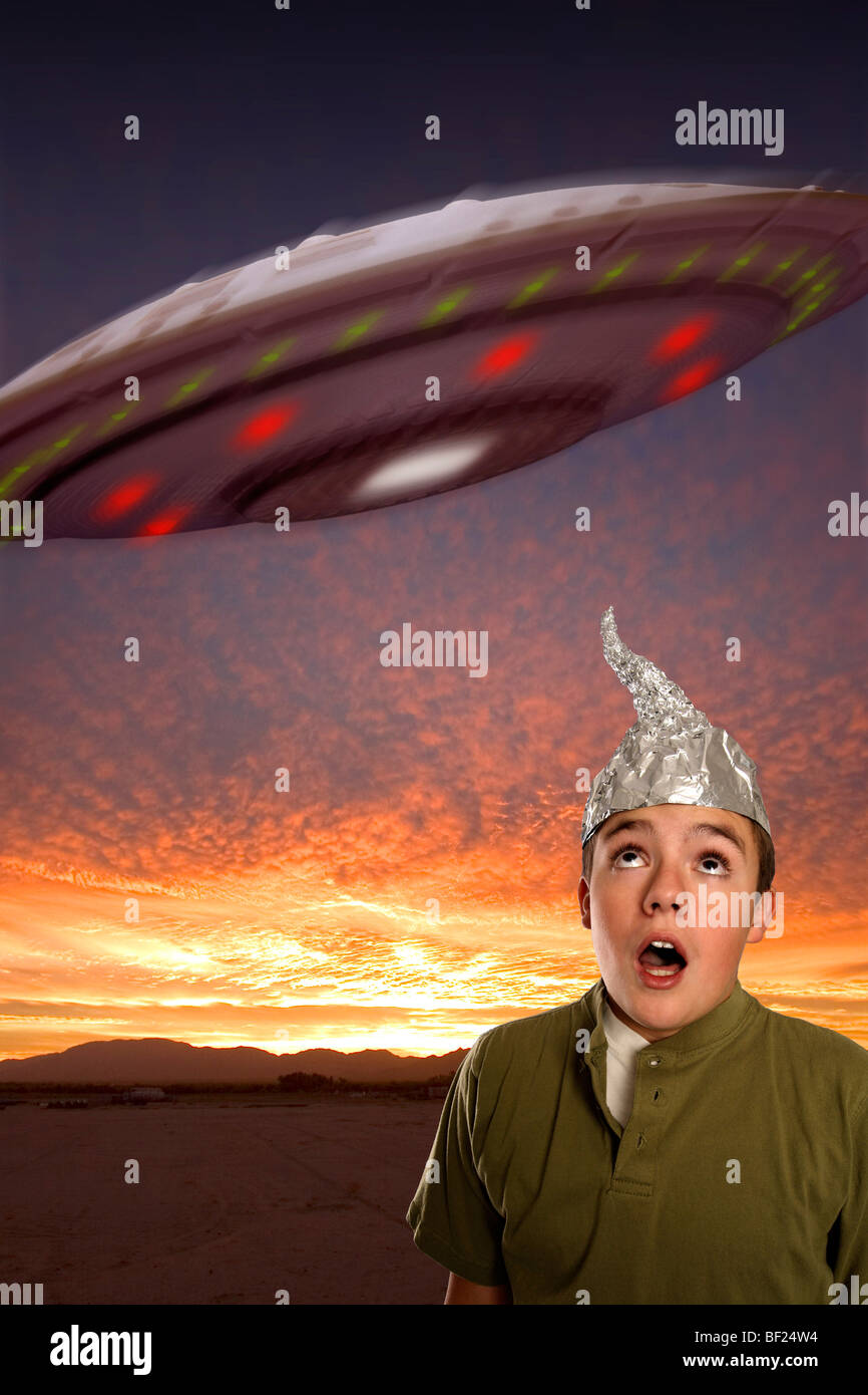 A boy, wearing a tinfoil hat observes a UFO in the sky Stock Photo Alamy