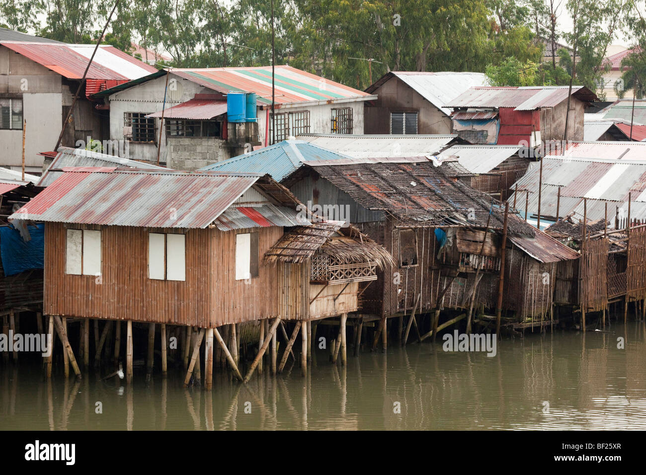 Shanty houses on stilts next to a river. Iloilo Philippines Stock Photo