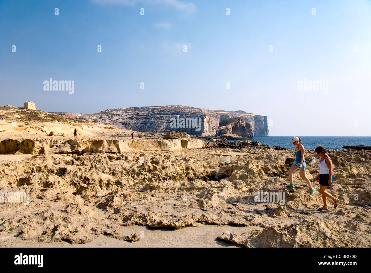 People walking over a cliff near Dwejra Point, Gozo, Malta, Europe Stock Photo