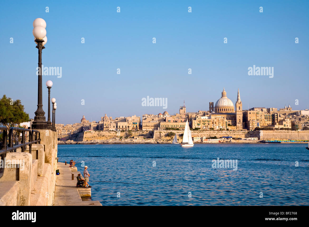 People at the promenade of Sliema with view at the town Valletta, Malta, Europe Stock Photo