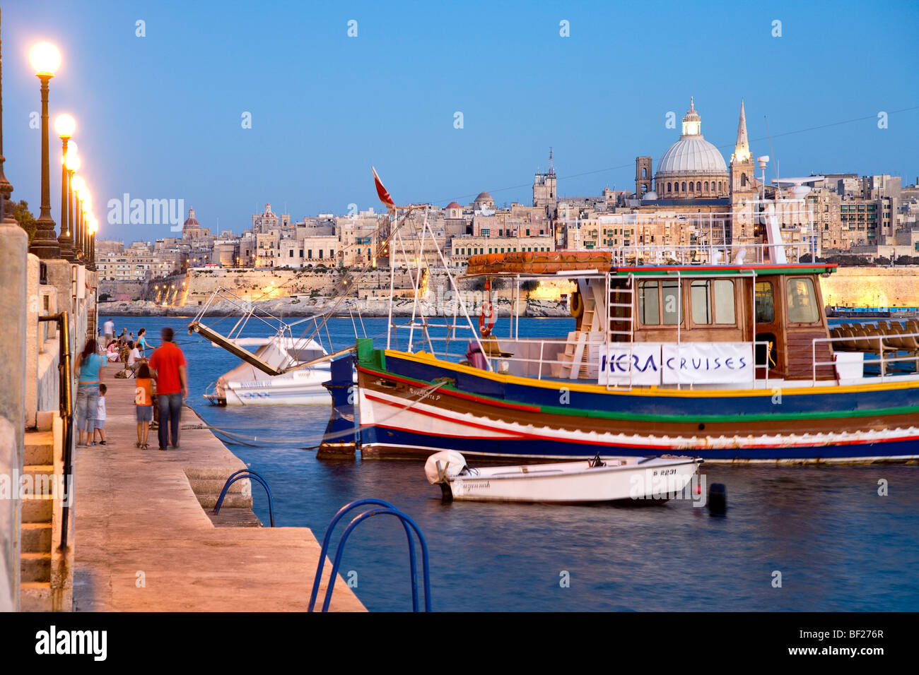 People on the promenade in the evening, view at the town of Valletta, Sliema, Malta, Europe Stock Photo