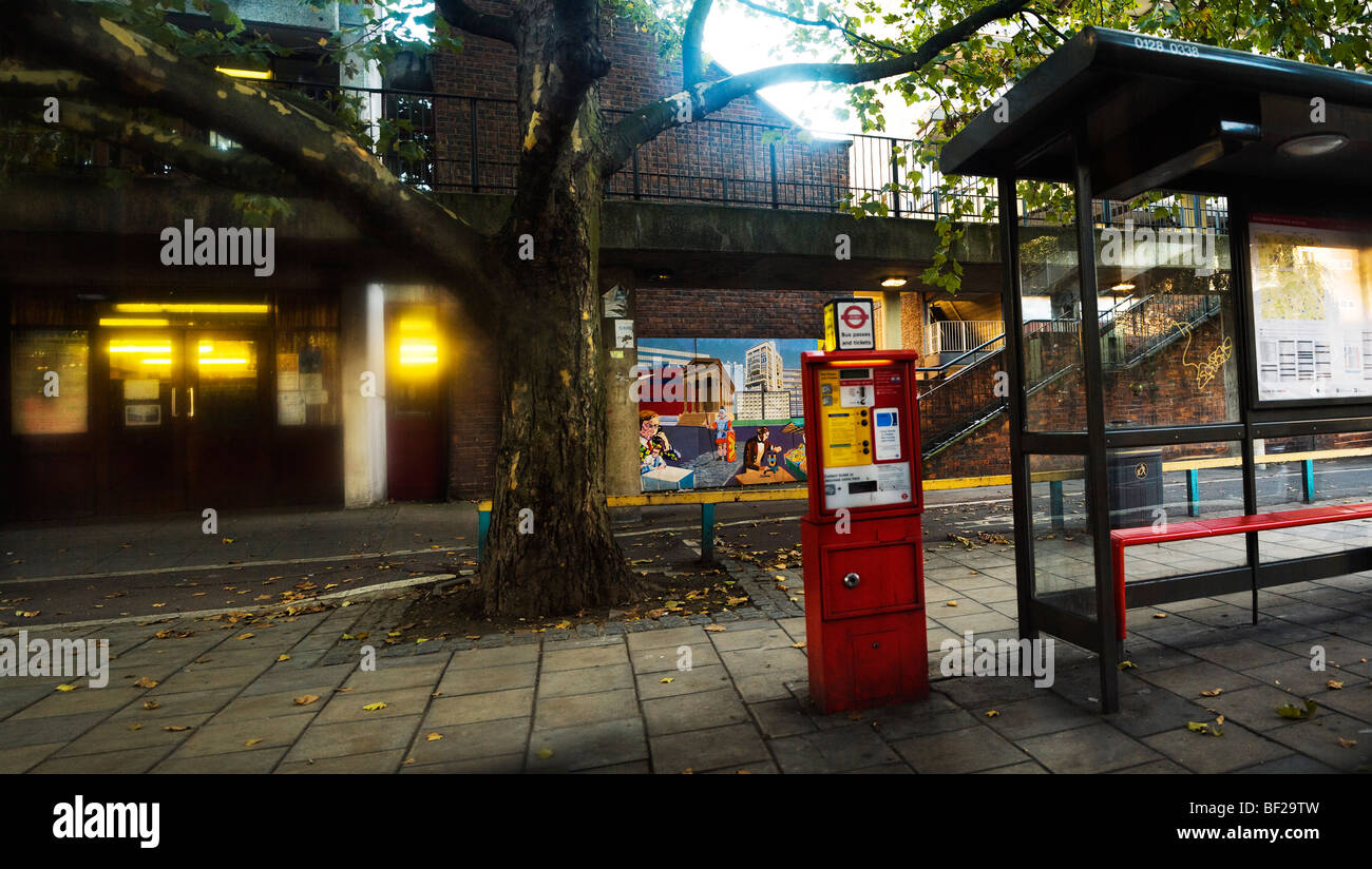 A bus stop, red ticket machine and tree on The Old Kent Road near Elephant and Castle, London England Stock Photo