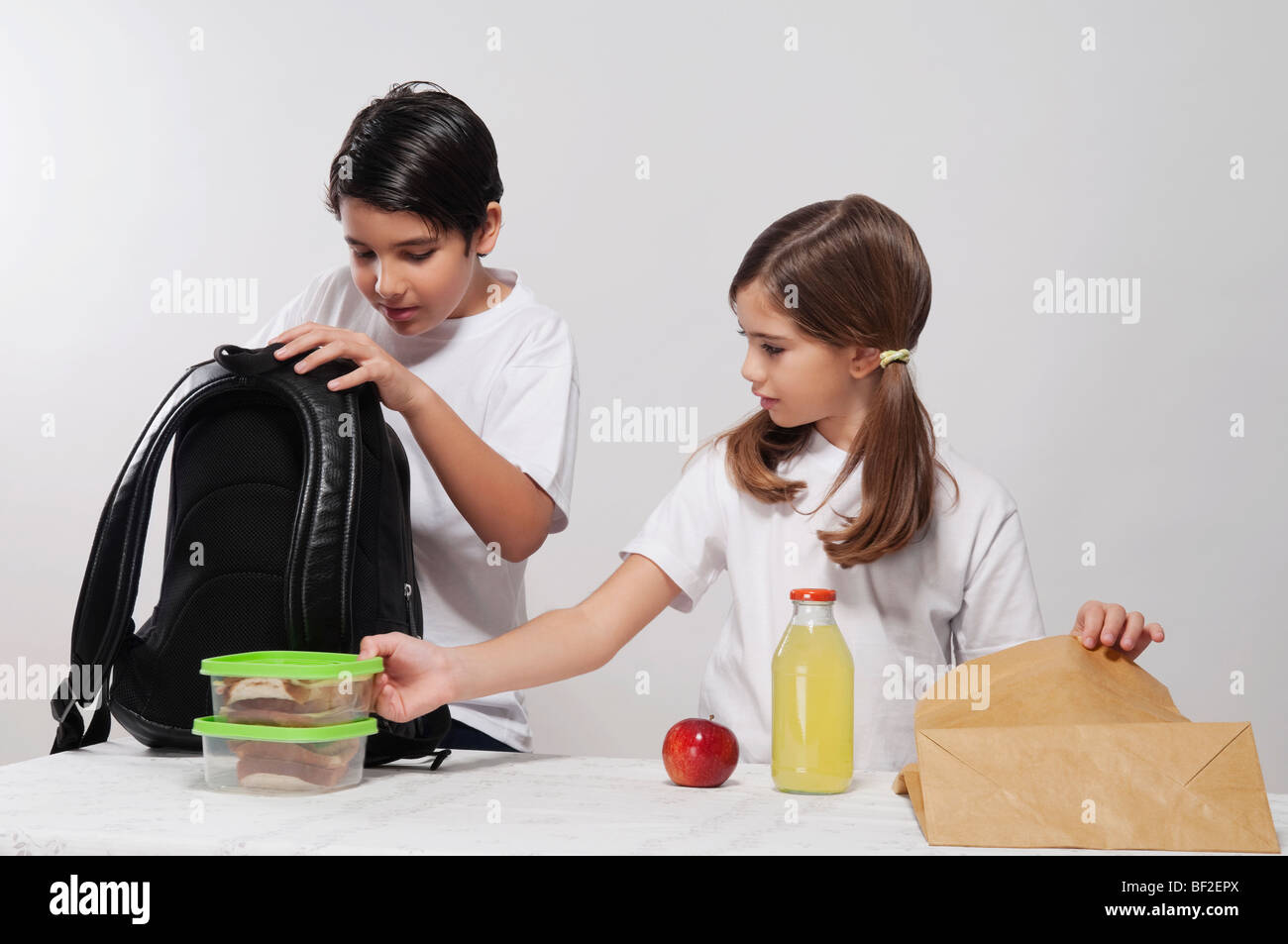 Boy and a girl packing their lunch for school Stock Photo