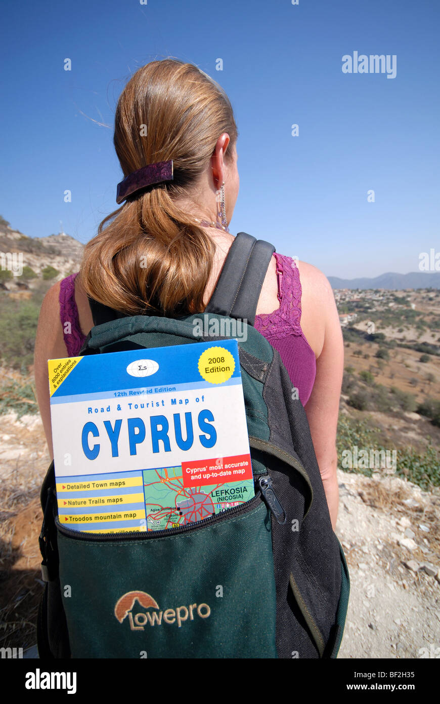 CYPRUS. A young woman hiking in the Cypriot countryside. Focus on Cyprus map in backpack. 2008