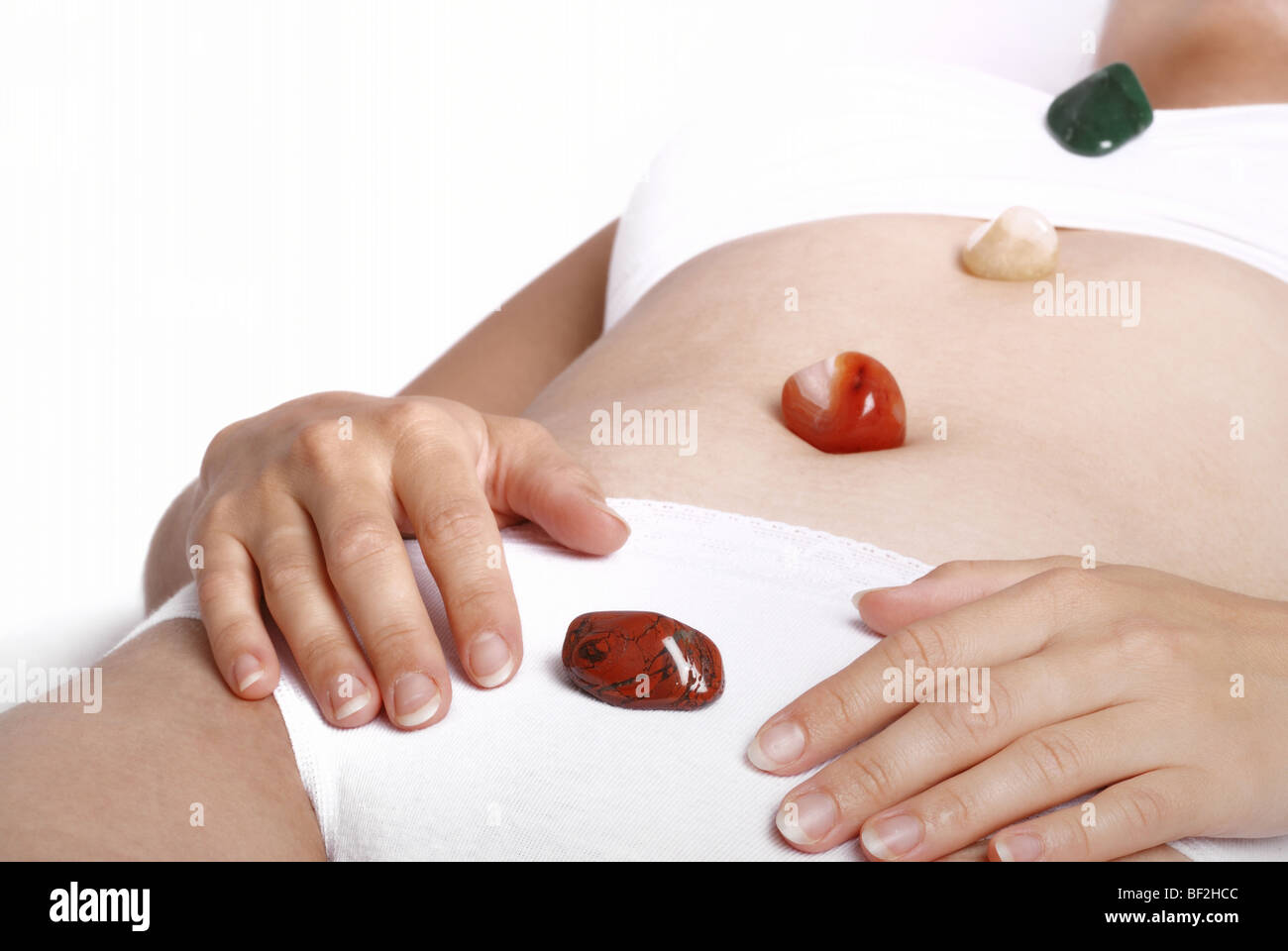 Alternative medicine - healing by semiprecious gems placed on body chakras, shallow depth of field Stock Photo