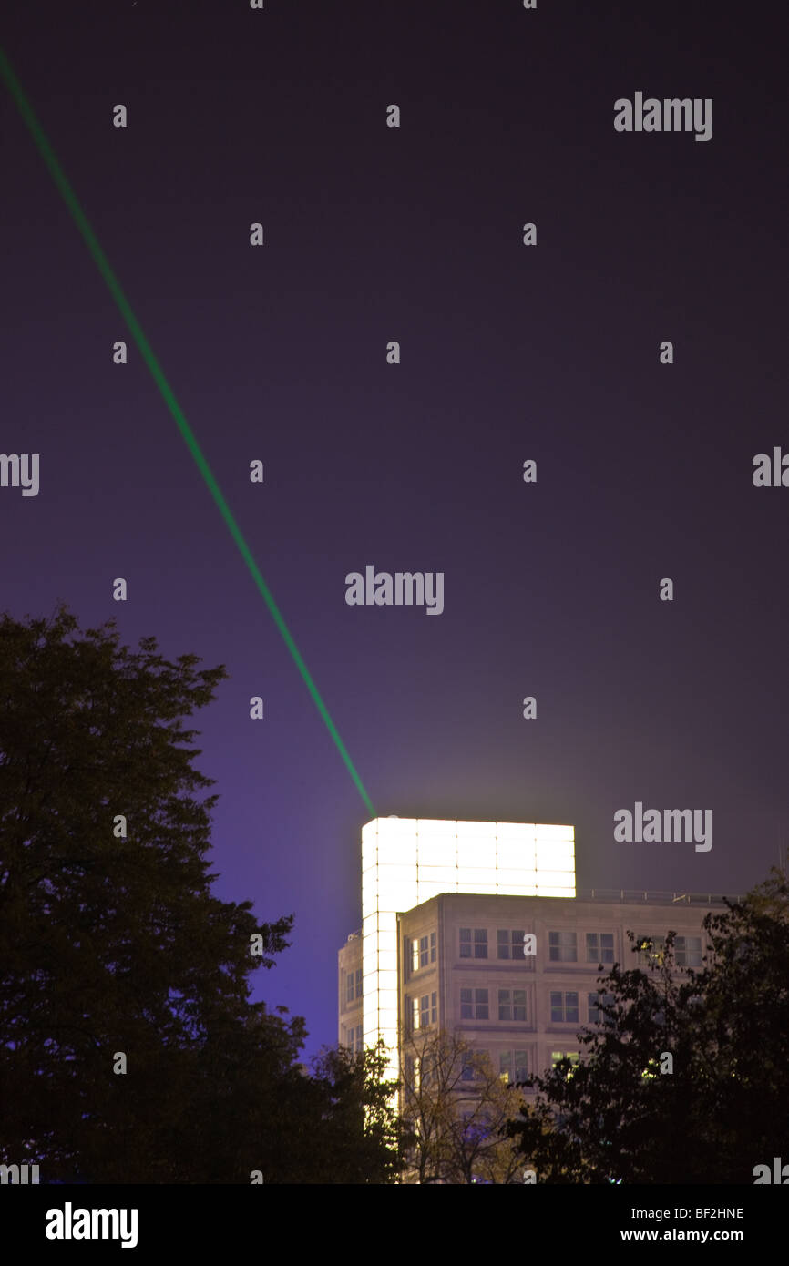 Skyline of Berlin at Night with single brightly lit Building and Laser Beam Stock Photo
