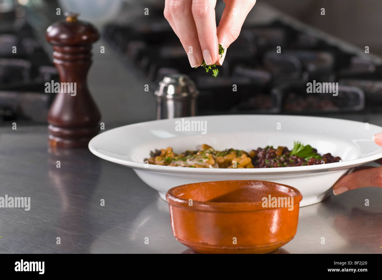 Cilantro Sprinkle Woman sprinkling cilantro to beans Stock Photo - Alamy