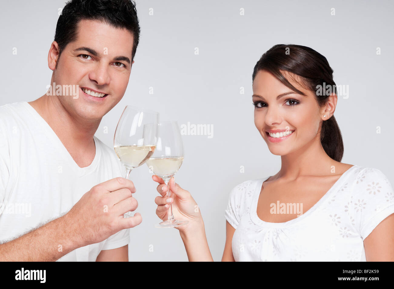 Couple toasting with white wine glasses Stock Photo Alamy