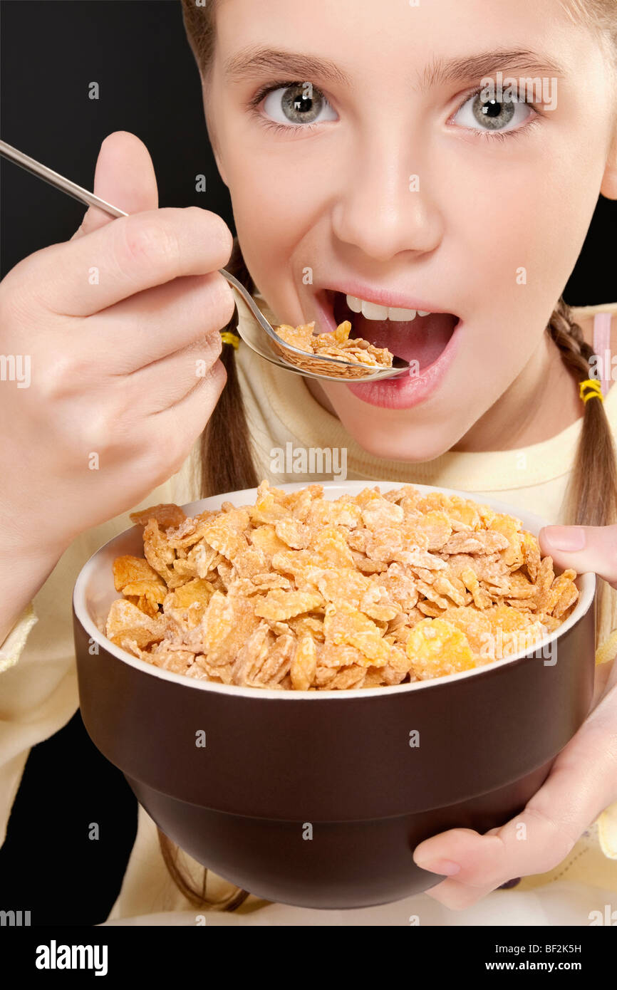 Portrait of a girl eating corn flakes Stock Photo - Alamy