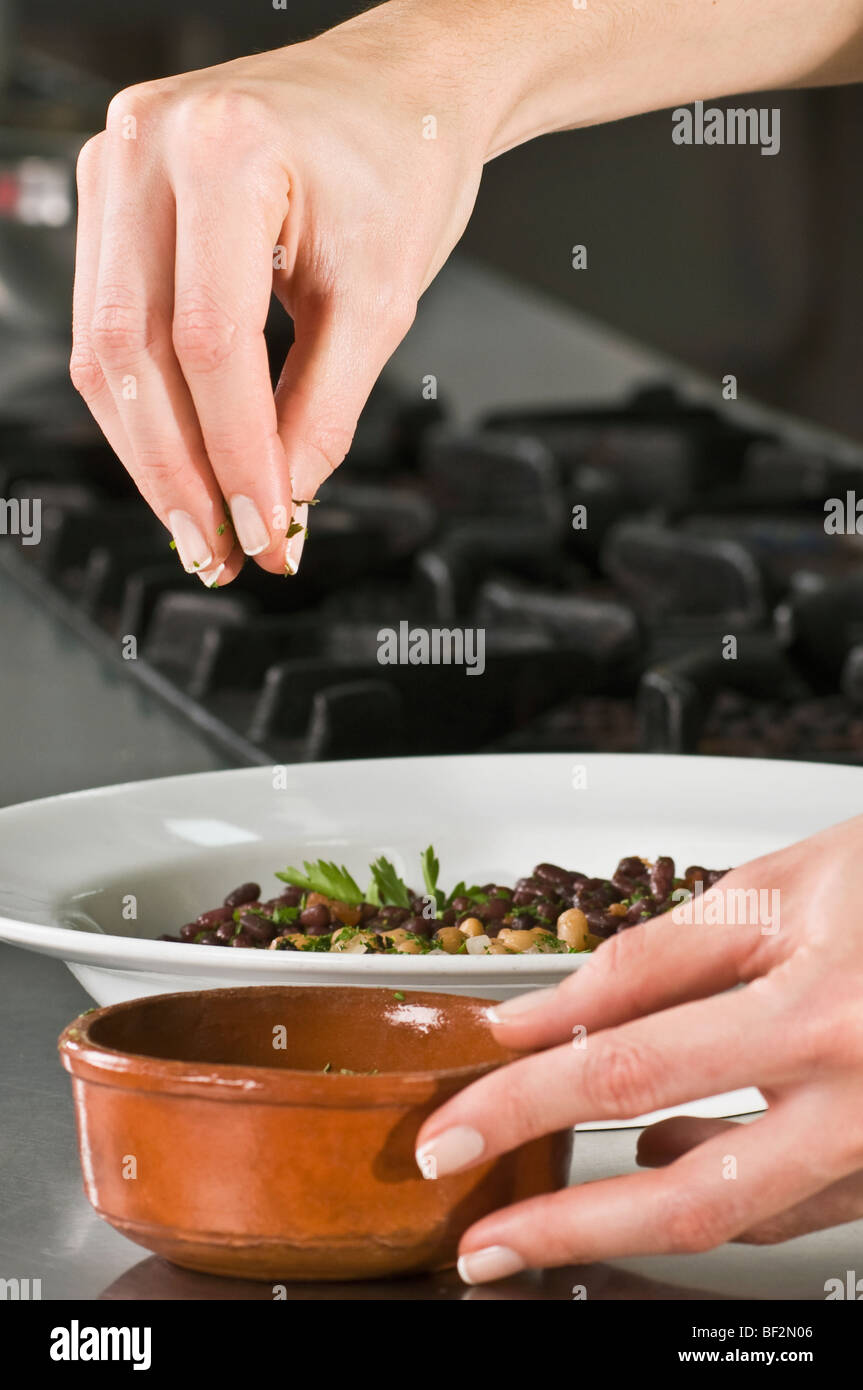 Cilantro Sprinkle Woman sprinkling cilantro to beans Stock Photo - Alamy