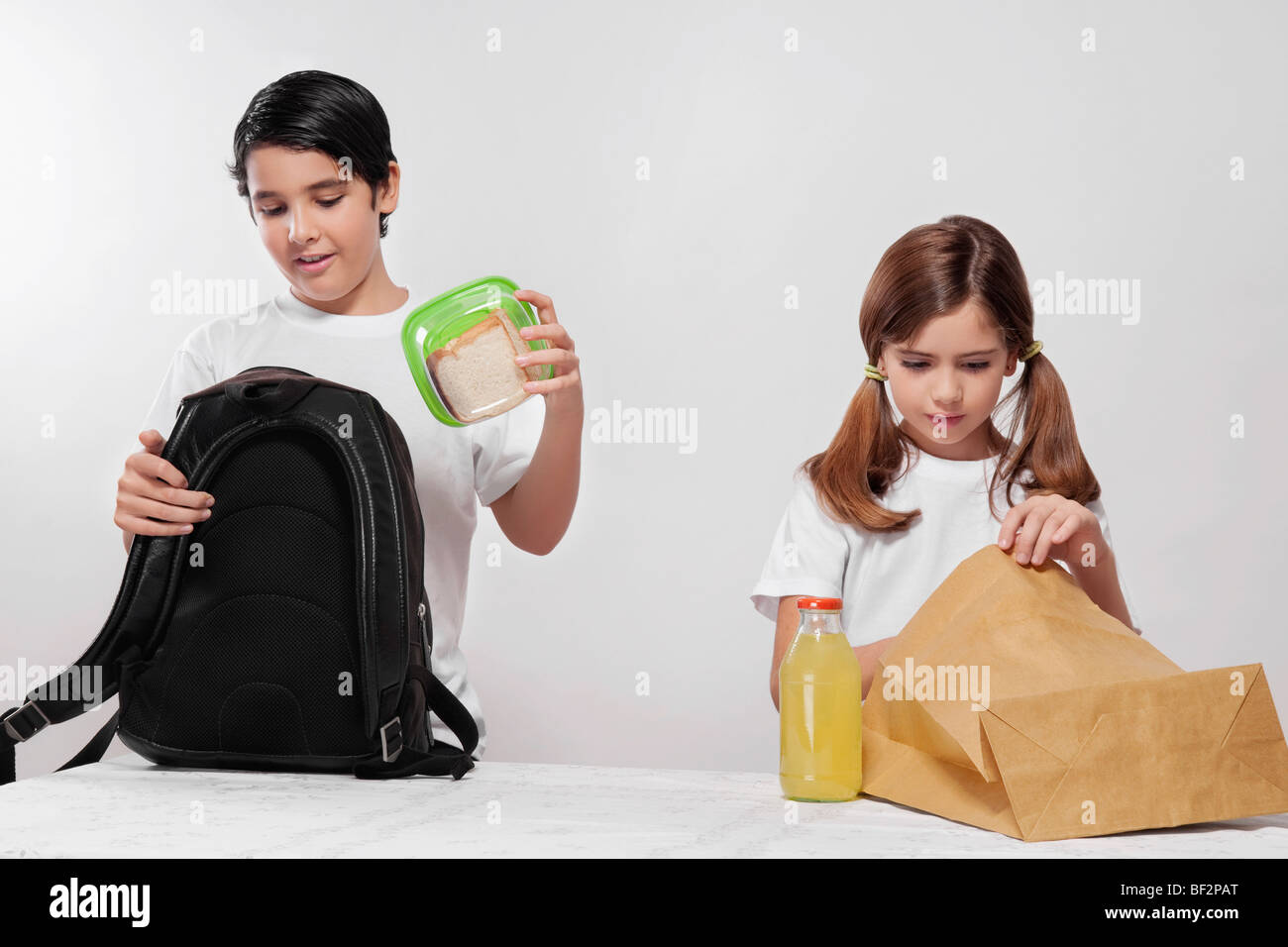 Boy and a girl packing their lunch for school Stock Photo