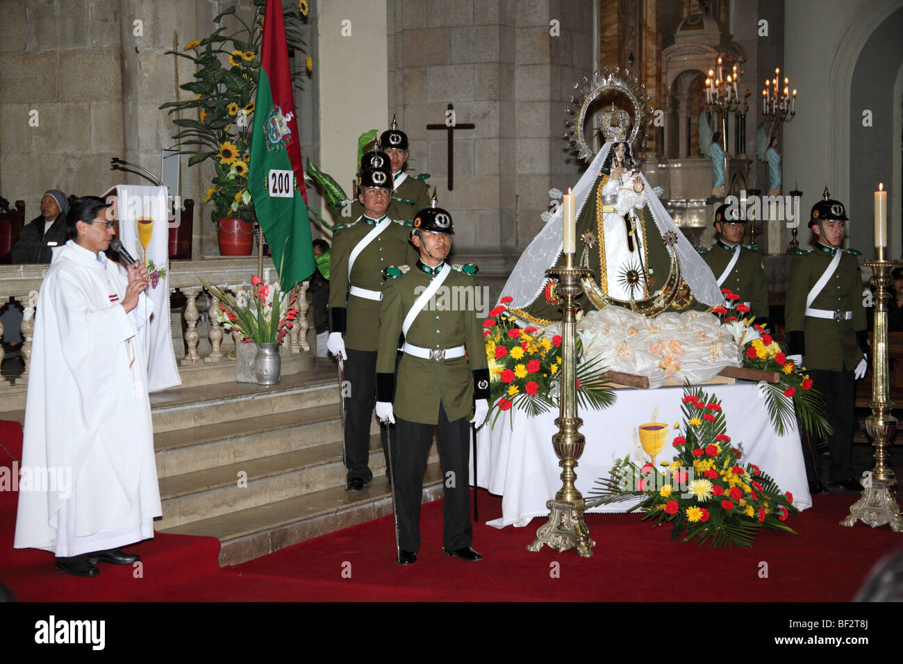 Police guard and the Virgen de Copacabana during mass for the police and Republic on 6th August Independence Day, La Paz cathedral, Bolivia Stock Photo