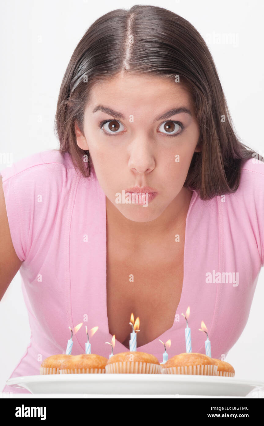 Woman blowing out candles on cupcakes Stock Photo Alamy