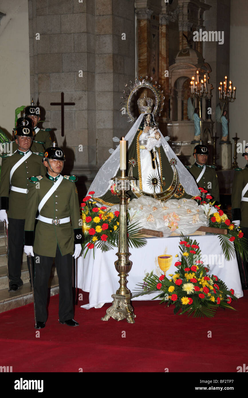 Police guard and the Virgen de Copacabana during mass for the police and Republic on 6th August Independence Day, La Paz cathedral, Bolivia Stock Photo