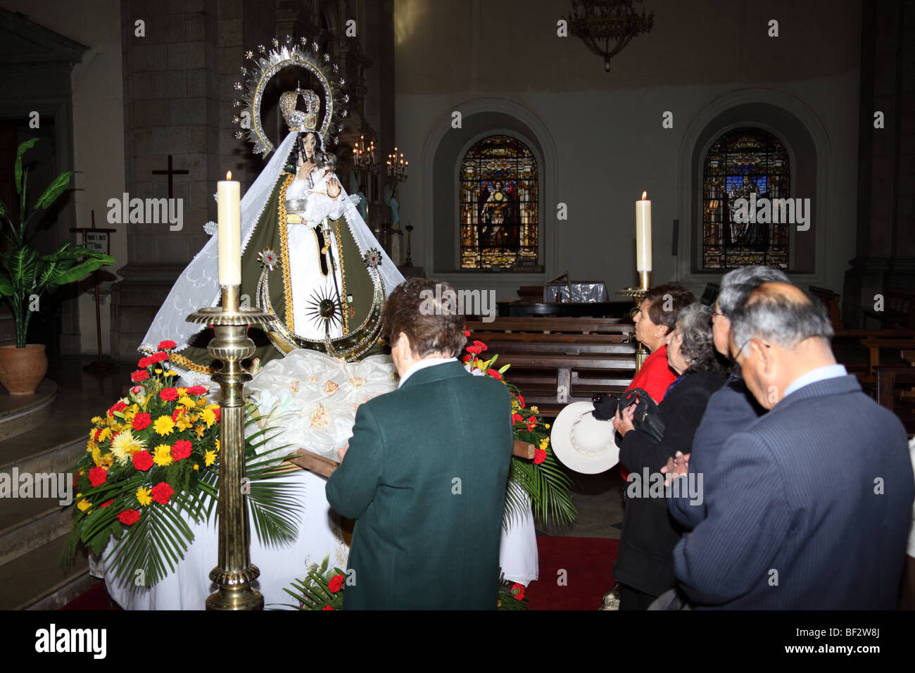 Devotees honour the Virgen de Copacabana (Bolivia's patron saint) after 6th August Independence Day mass , La Paz cathedral , Bolivia Stock Photo