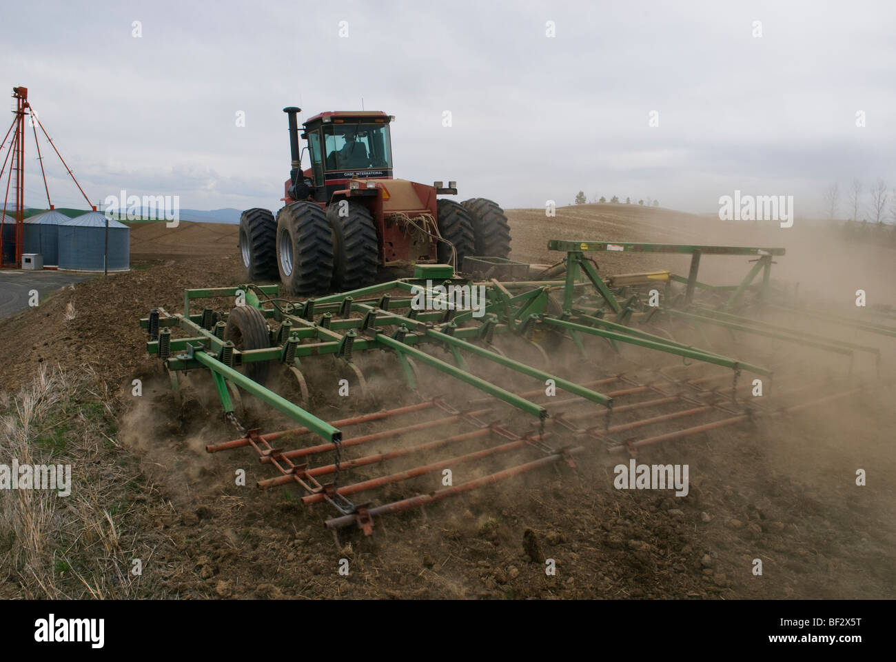 A tractor and cultivator preparing a field for planting garbanzo beans