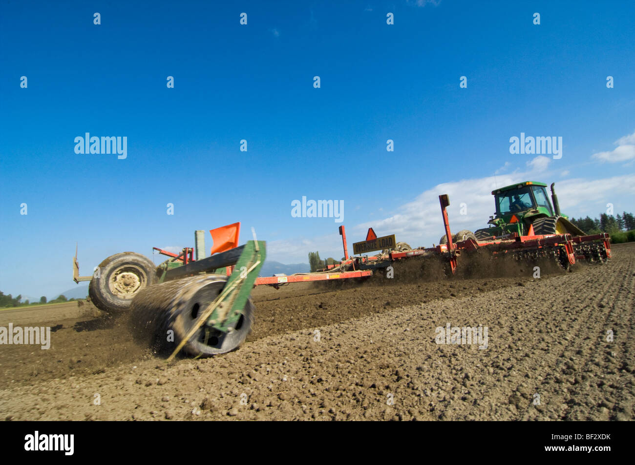 Agriculture - A tractor pulling a mulcher prepares a seedbed for planting potatoes / near Burlington, Washington, USA. Stock Photo