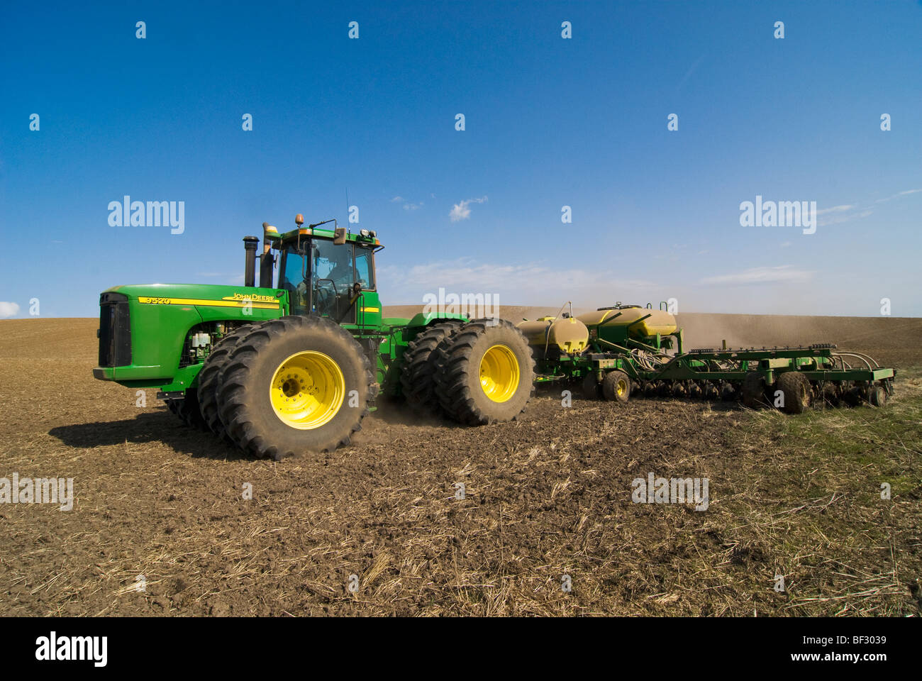 A John Deere tractor and air seeder planting garbanzo beans (chick peas) in the rolling hills of the Palouse / Washington, USA. Stock Photo