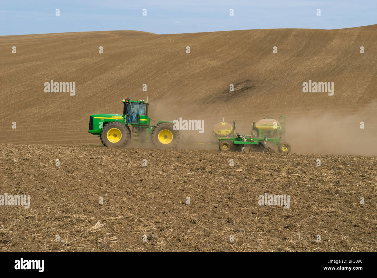 A John Deere tractor and air seeder planting garbanzo beans (chick peas) in the rolling hills of the Palouse / Washington, USA. Stock Photo