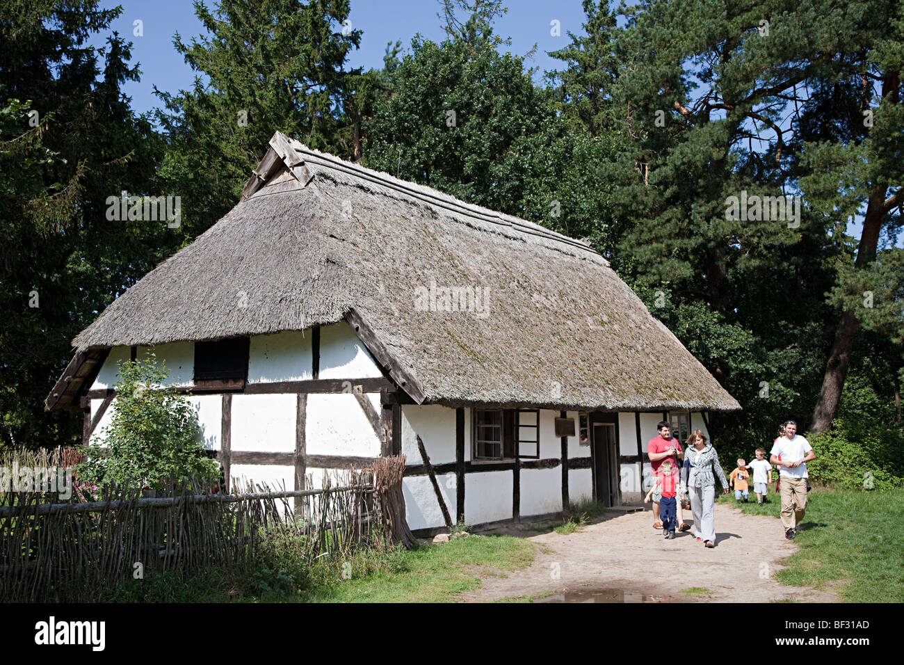 Timbered thatched homestead with people Kluki open air museum Poland Stock Photo