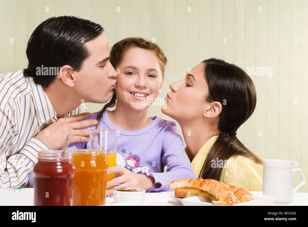 Couple kissing their daughter Stock Photo