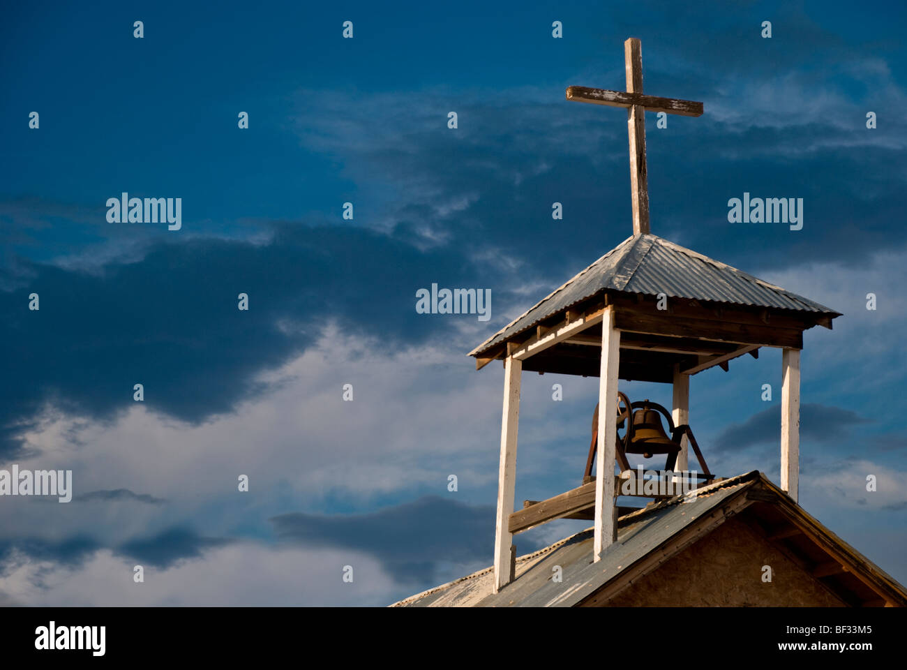 A crooked bell tower and cross top 'La Divina Providencia' church near Manzano, New Mexico. Stock Photo