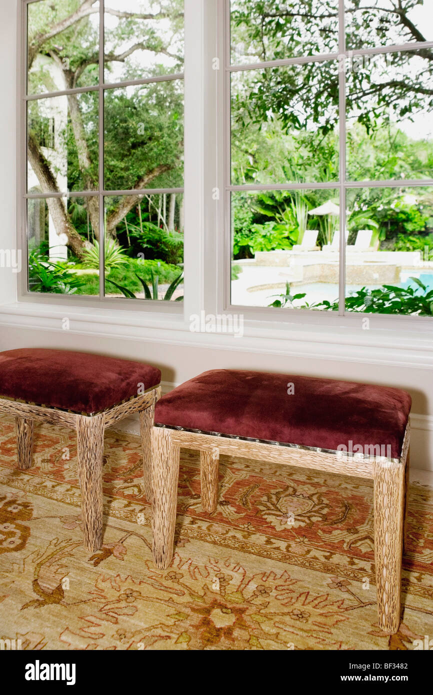Wooden stools near a window Stock Photo - Alamy