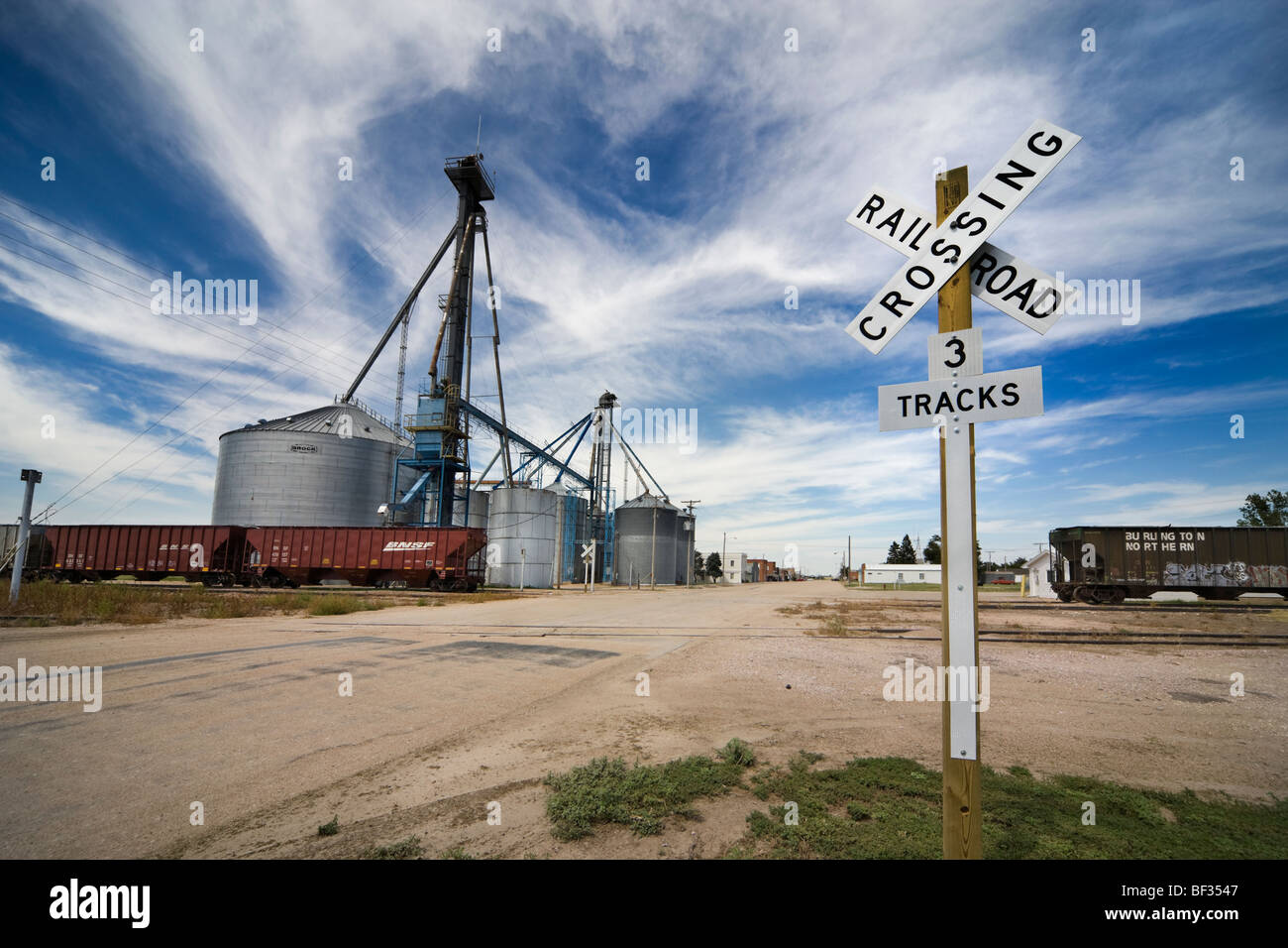 Entrance to McDonald Kansas with rail road crossing sign, trains and grain elevator. Stock Photo