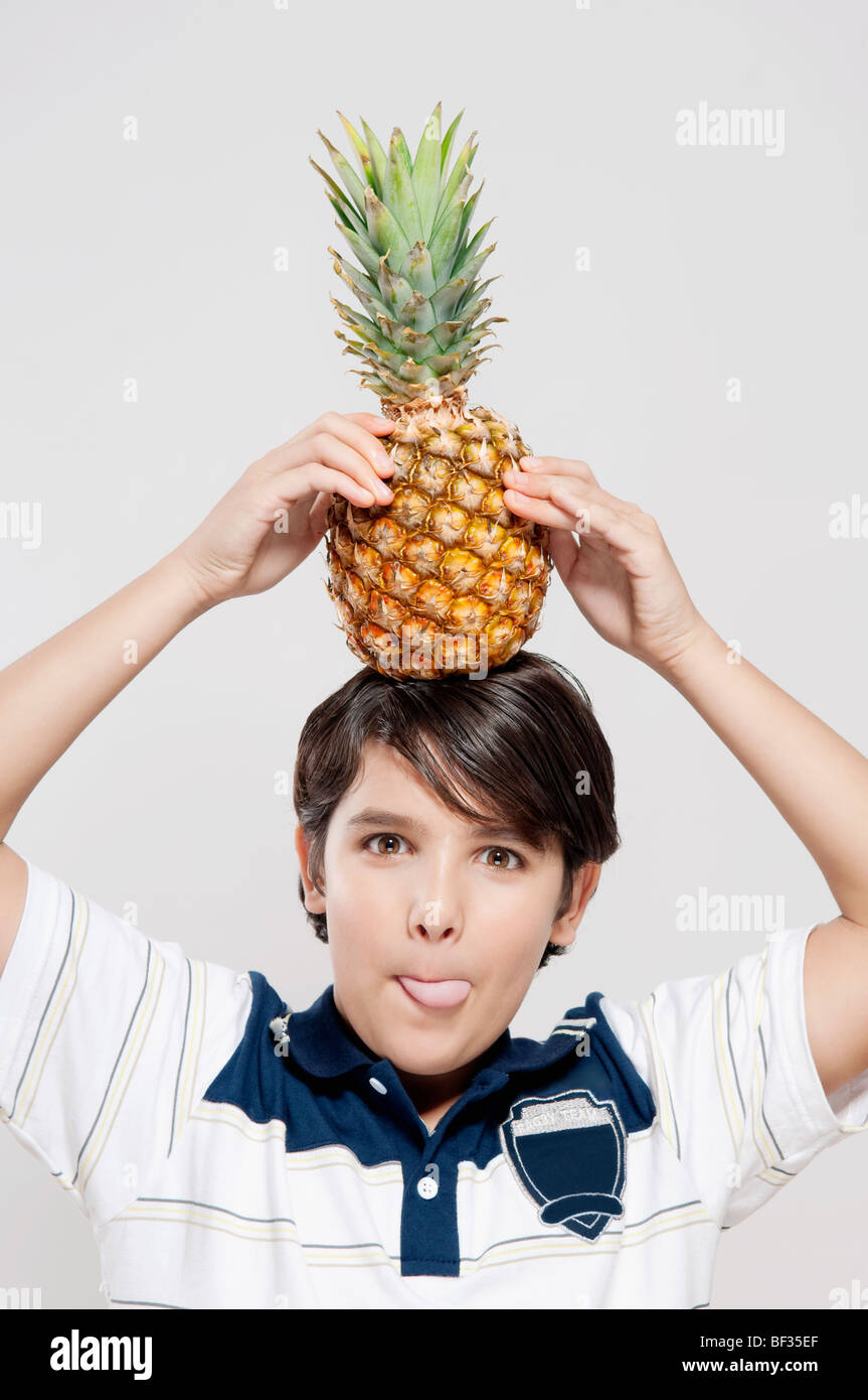 Portrait of a boy carrying a pineapple on his head Stock Photo Alamy