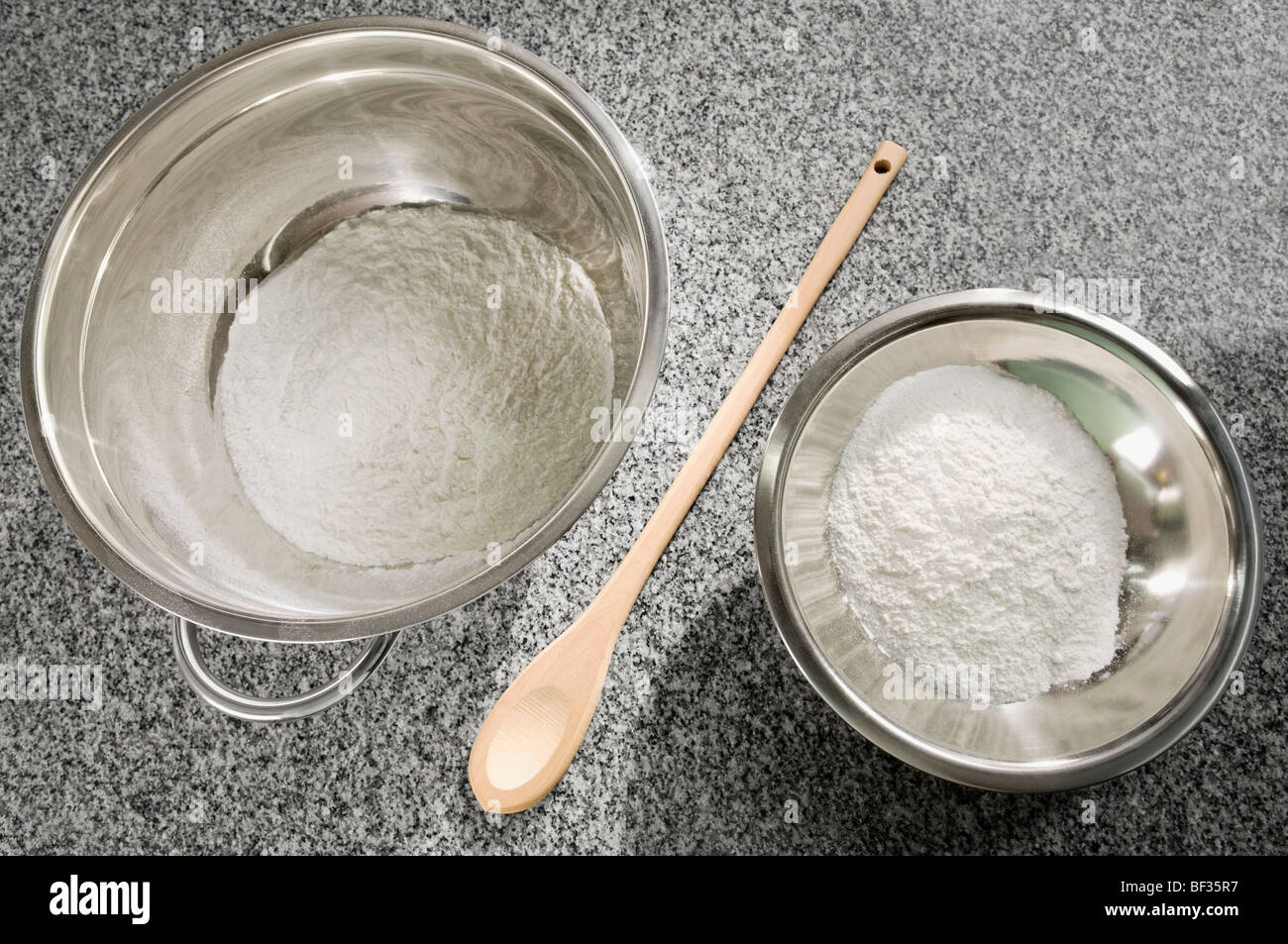 Close-up two bowls of flour with a wooden spoon Stock Photo