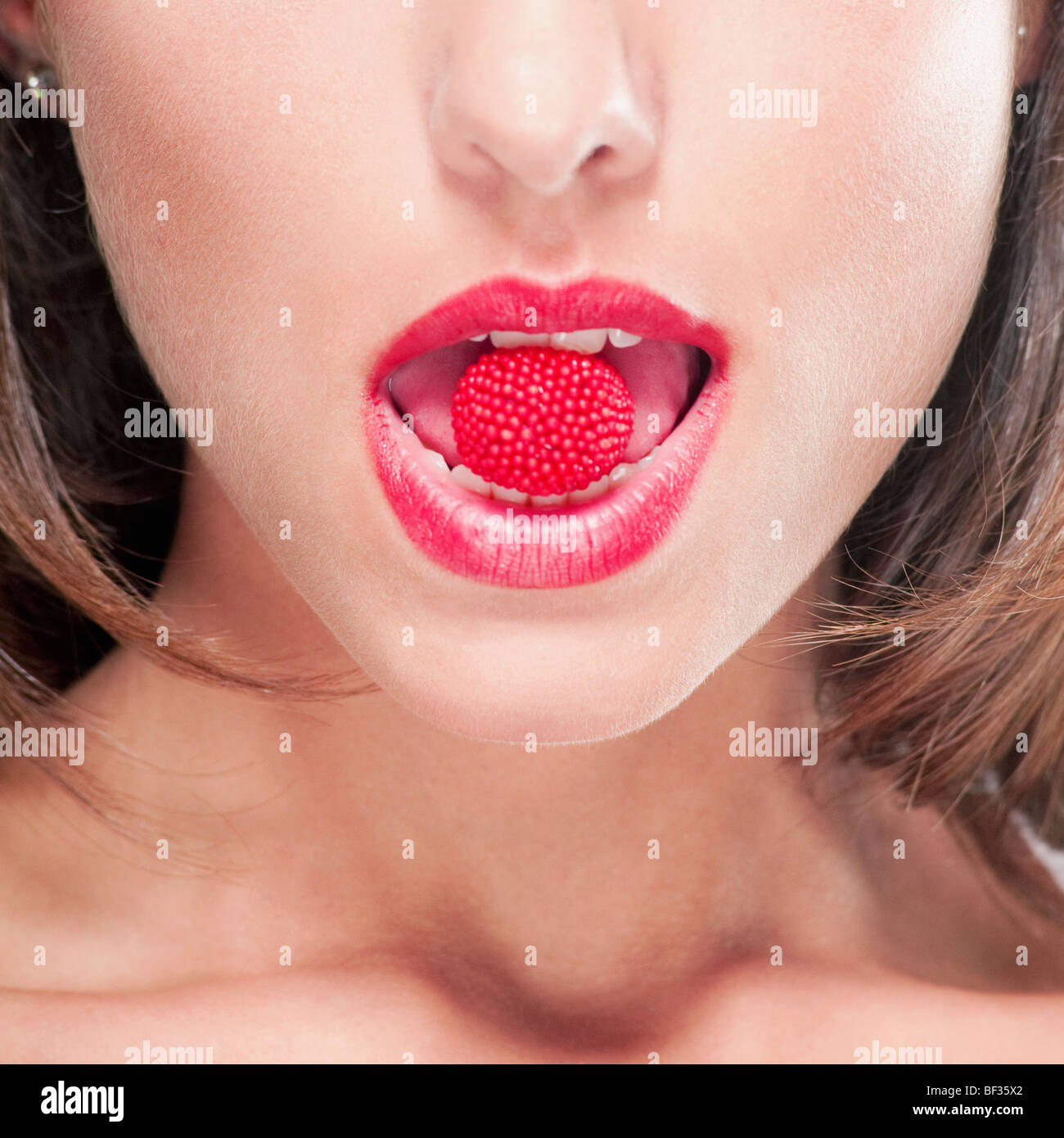 Closeup of a raspberry in a woman's mouth Stock Photo Alamy