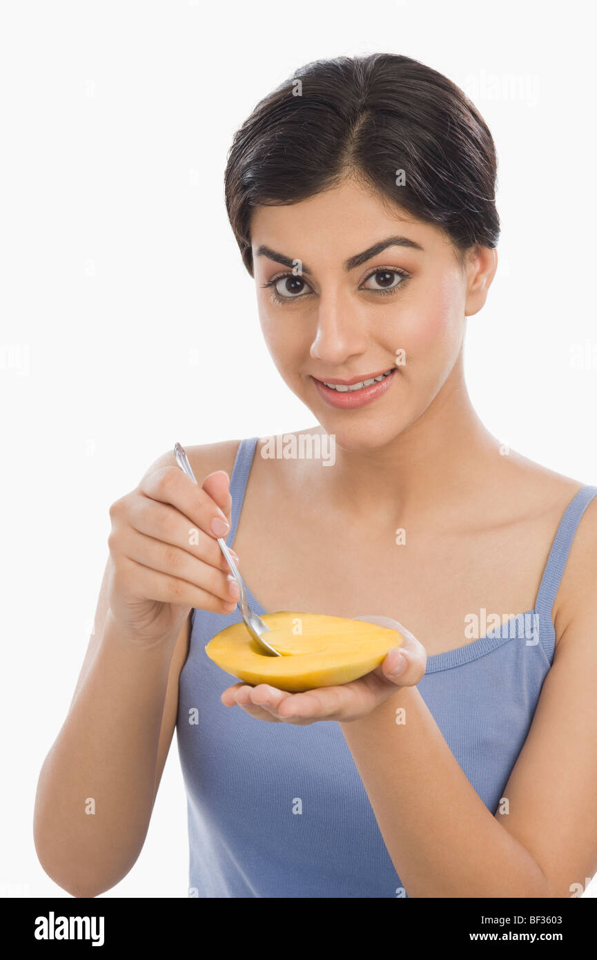Portrait of a woman eating mango with a spoon Stock Photo Alamy