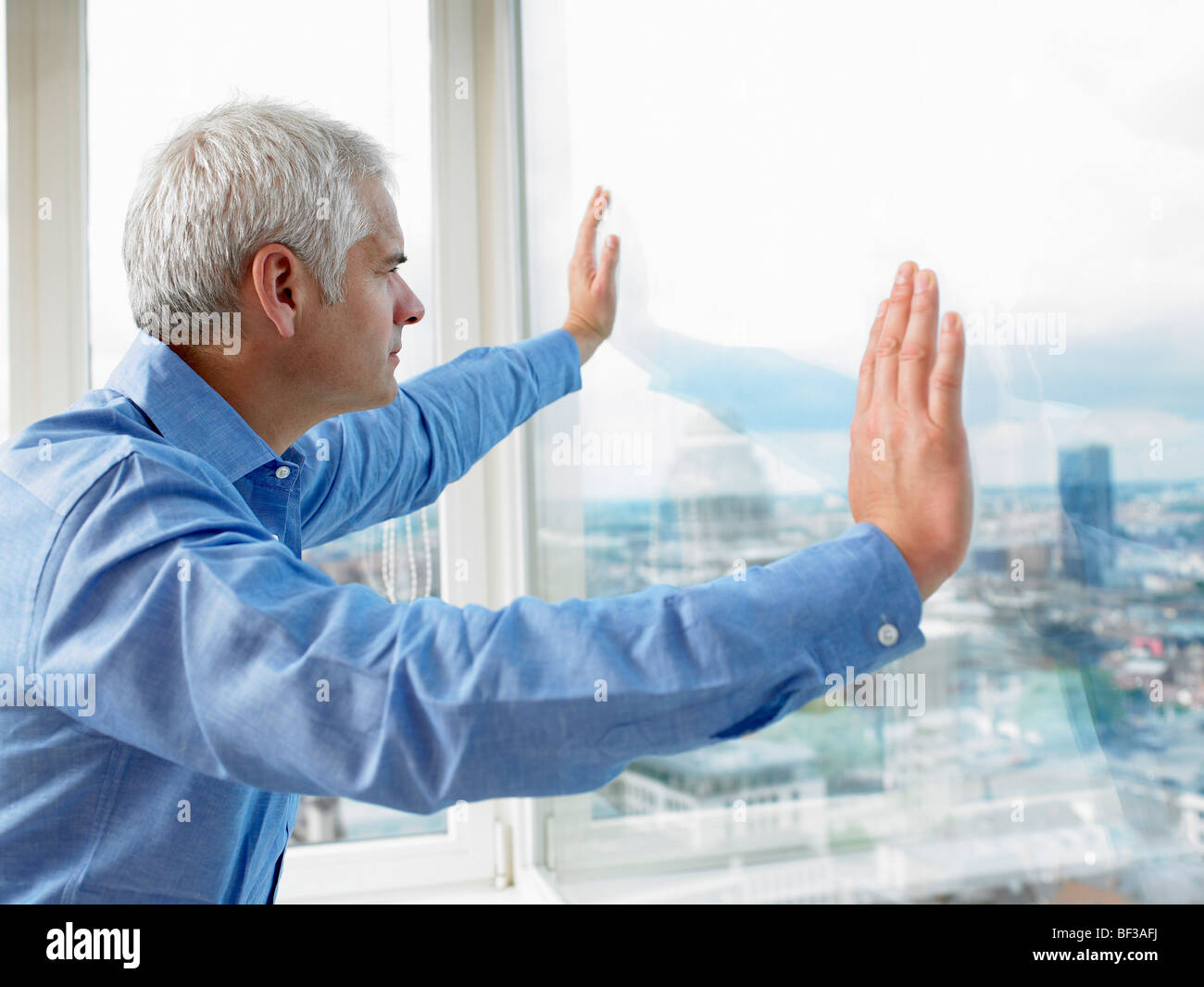 Business Man looking through window Stock Photo