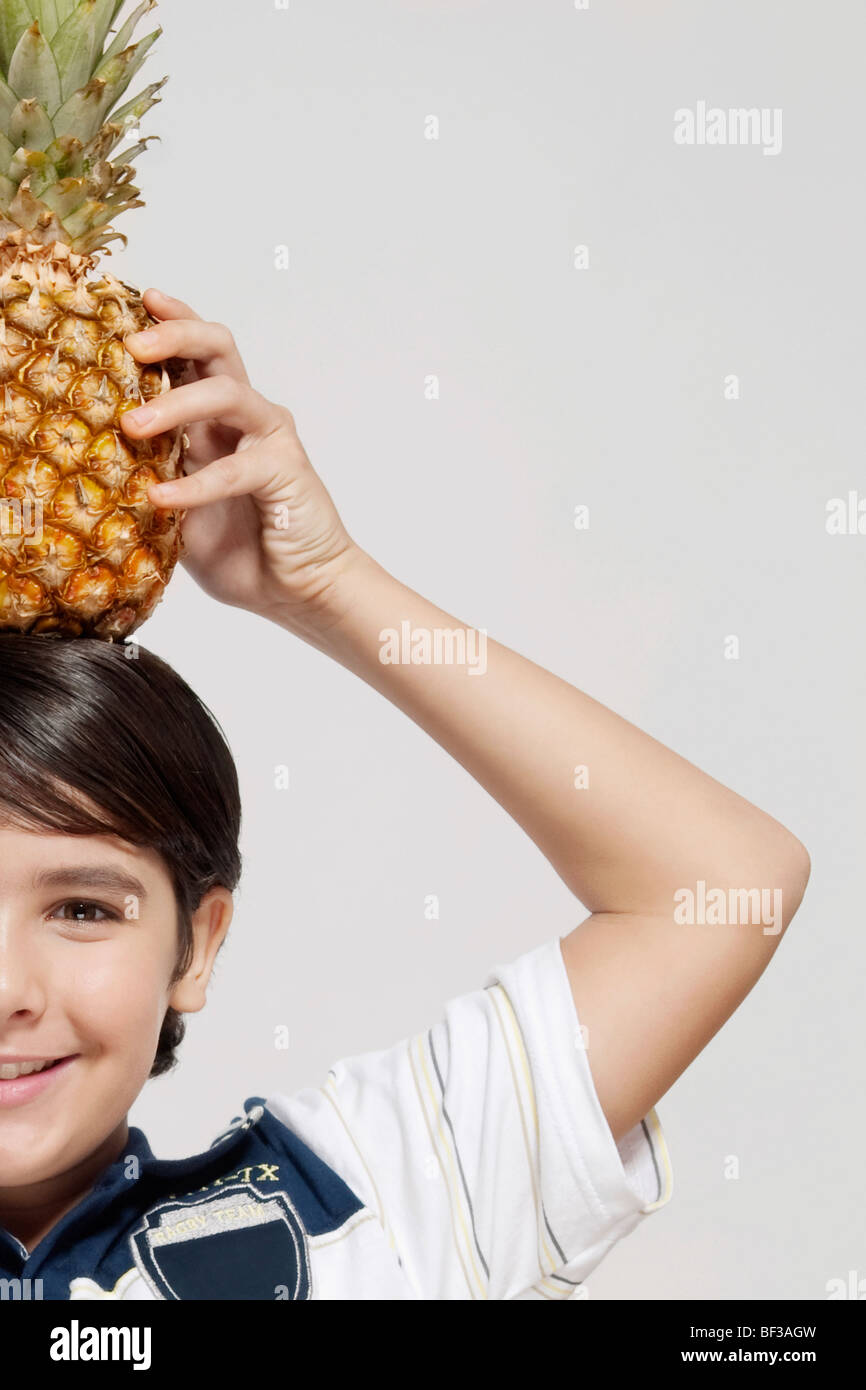 Closeup of a boy carrying a pineapple on his head Stock Photo Alamy