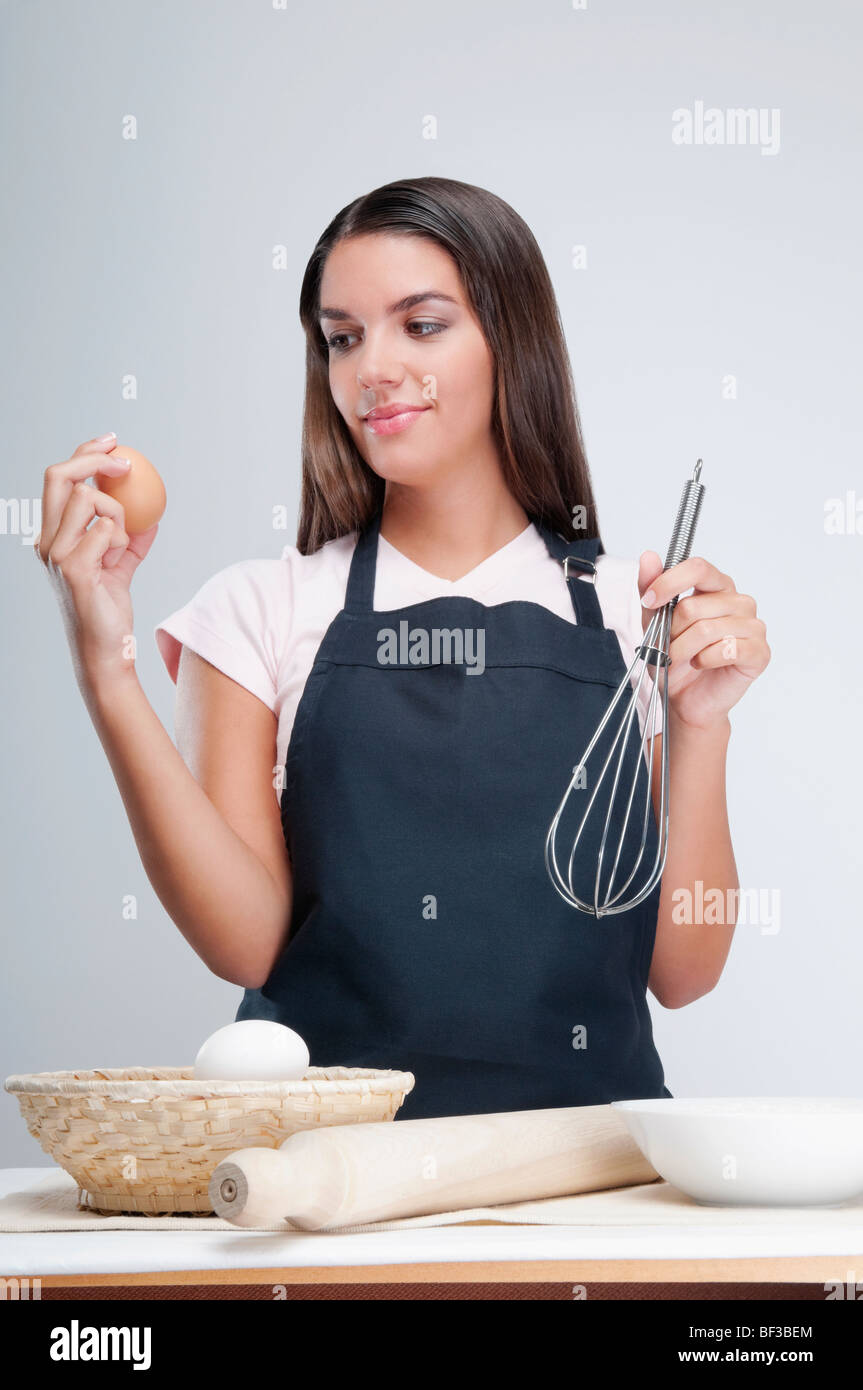Woman holding an egg and wire whisk Stock Photo