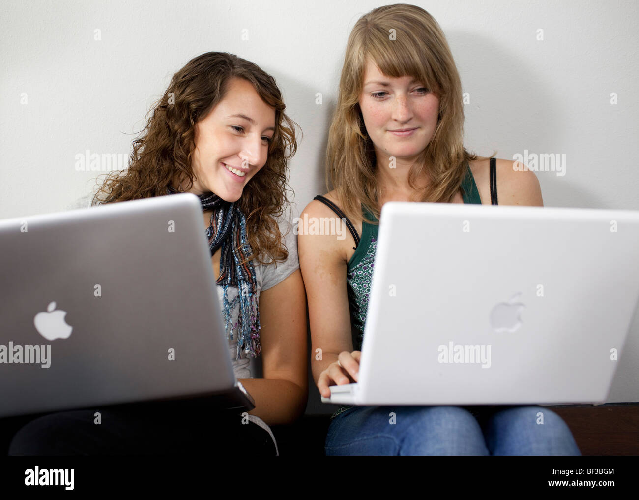 Friends sitting on the floor with notebooks Stock Photo