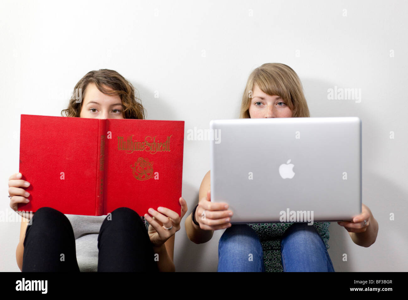 Friends sitting on the floor with notebook and book . Stock Photo