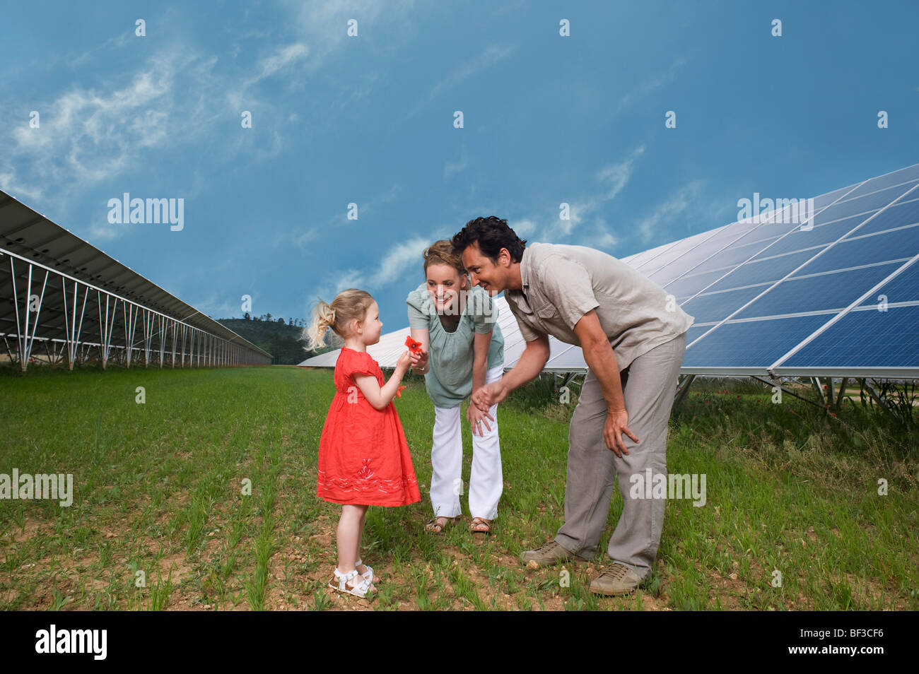 family in front of solar panel Stock Photo