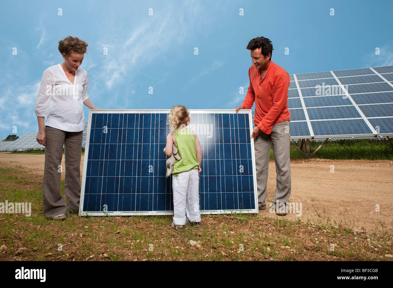 family in front of solar panel Stock Photo