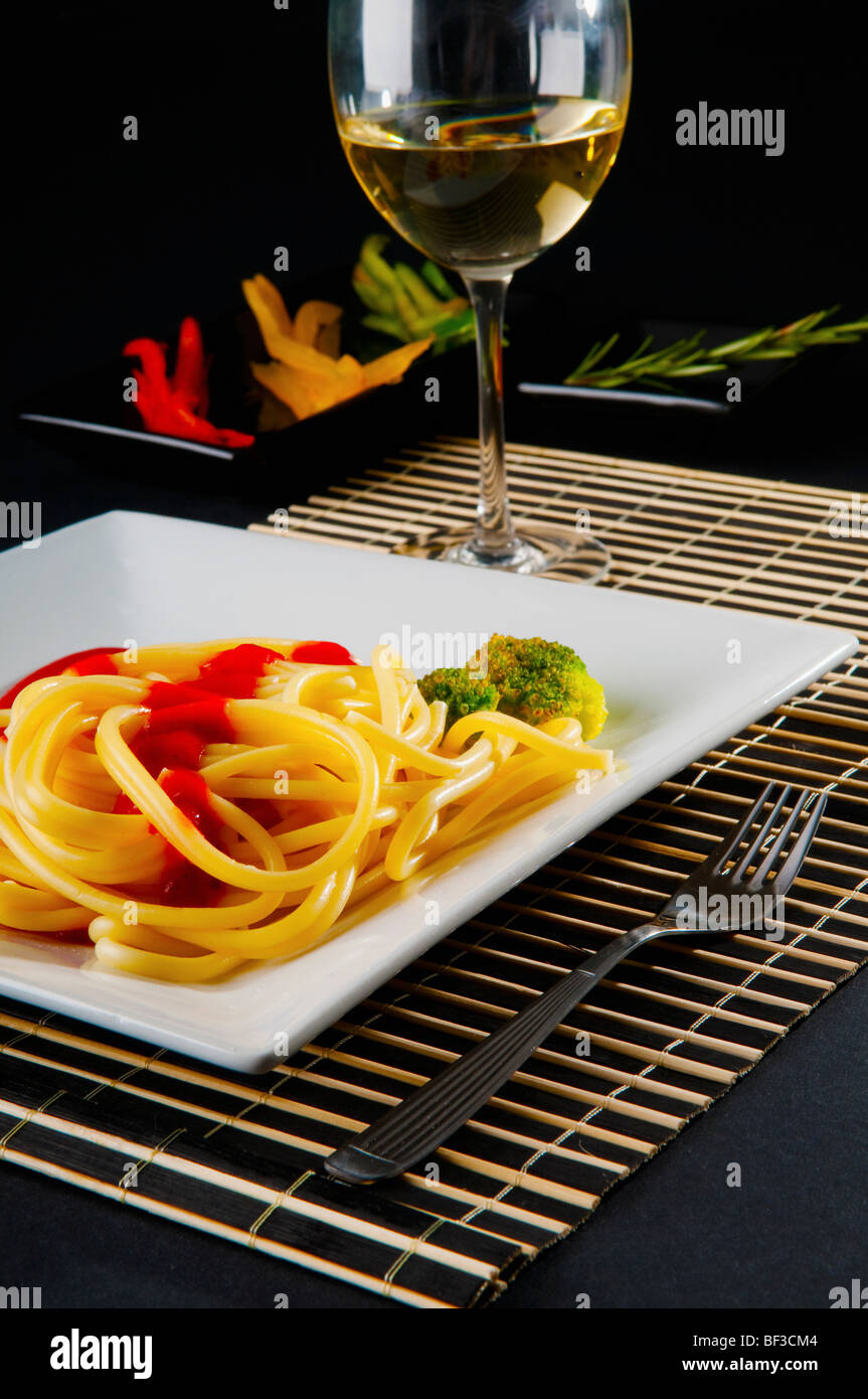 Spaghetti pasta and tomato sauce served with white wine Stock Photo