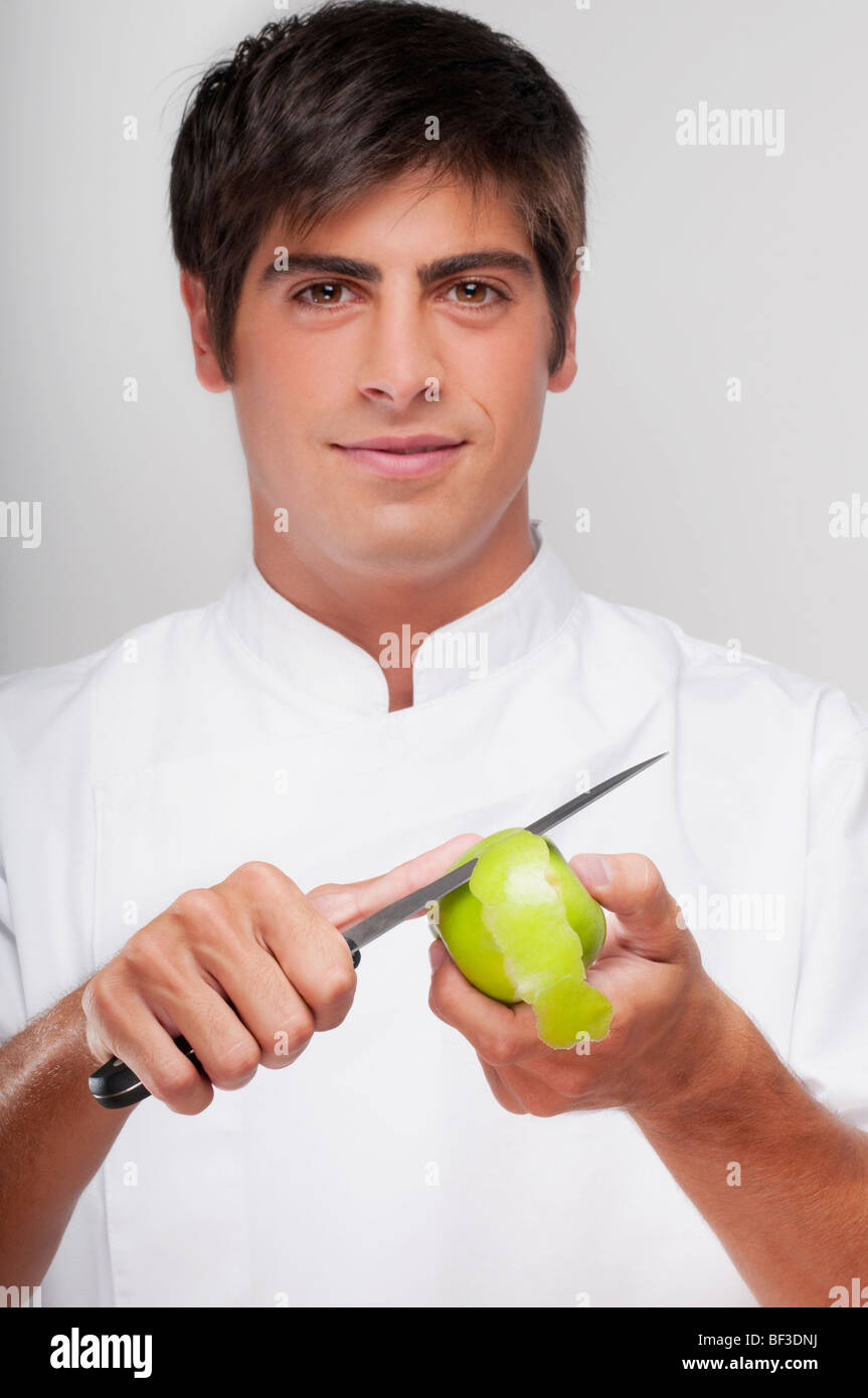 Man peeling a granny smith apple and smiling Stock Photo - Alamy