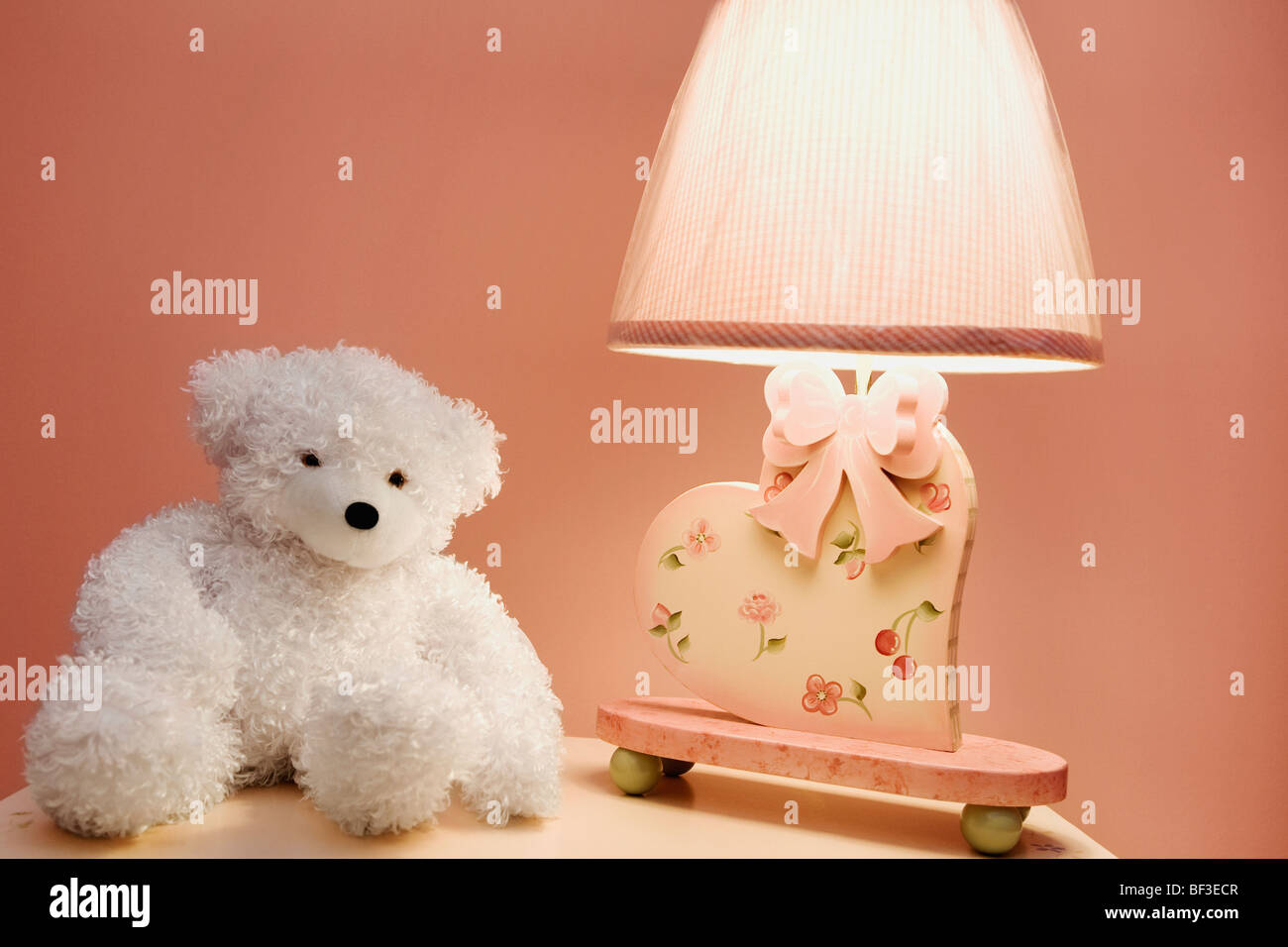 Stuffed toy and a lamp on a night table Stock Photo