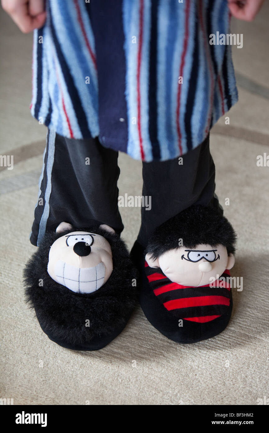 A young boy wearing Dennis the Menace and gnasher slippers Stock Photo Alamy