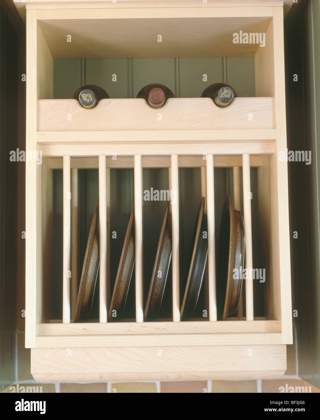 https://c8.alamy.com/comp/BF3JG6/close-up-of-plate-rack-and-wine-storage-in-pale-wood-kitchen-unit-BF3JG6.jpg