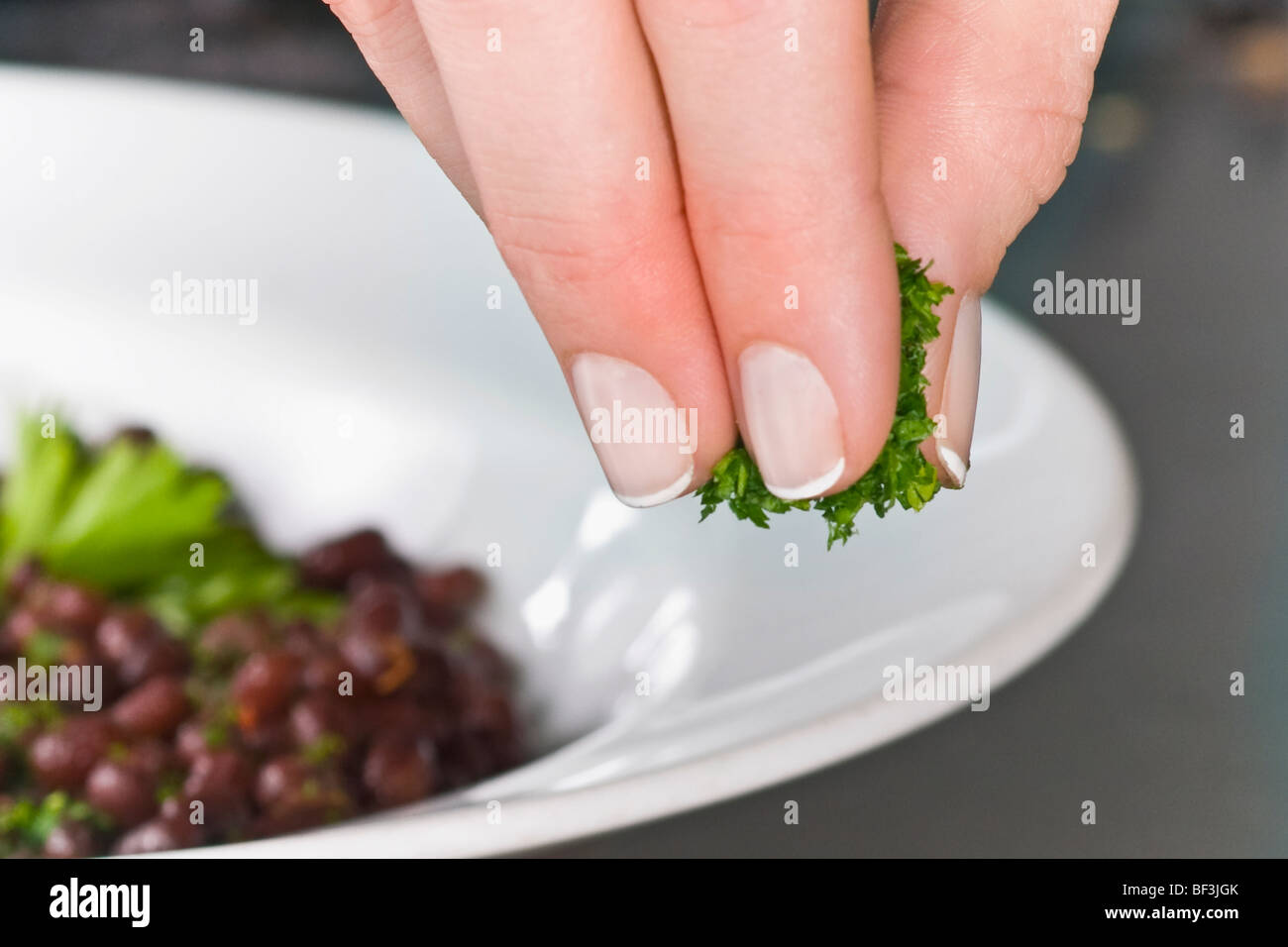 Cilantro Sprinkle Woman sprinkling cilantro to beans Stock Photo - Alamy