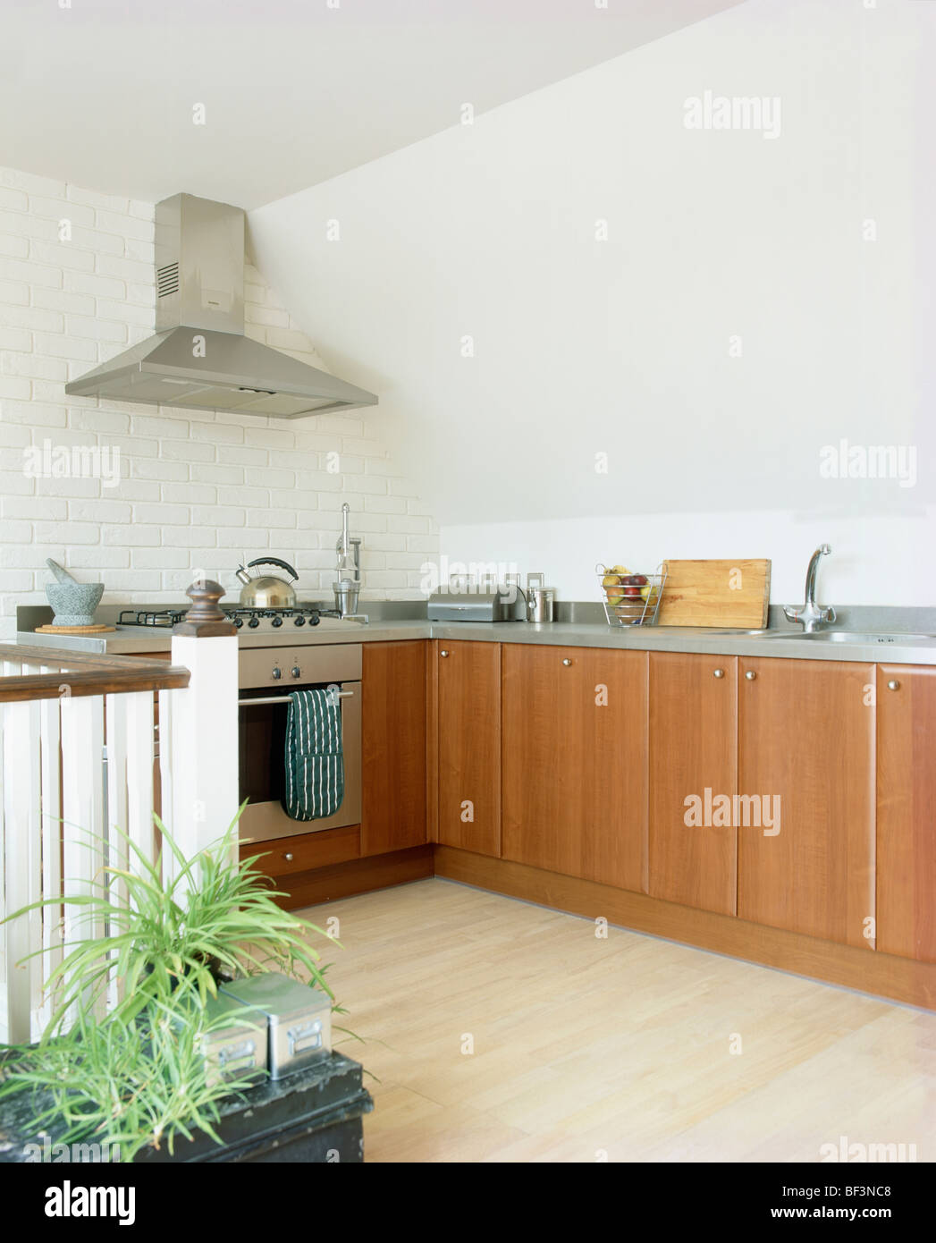 Laminate wood flooring in modern kitchen with fitted wooden units Stock