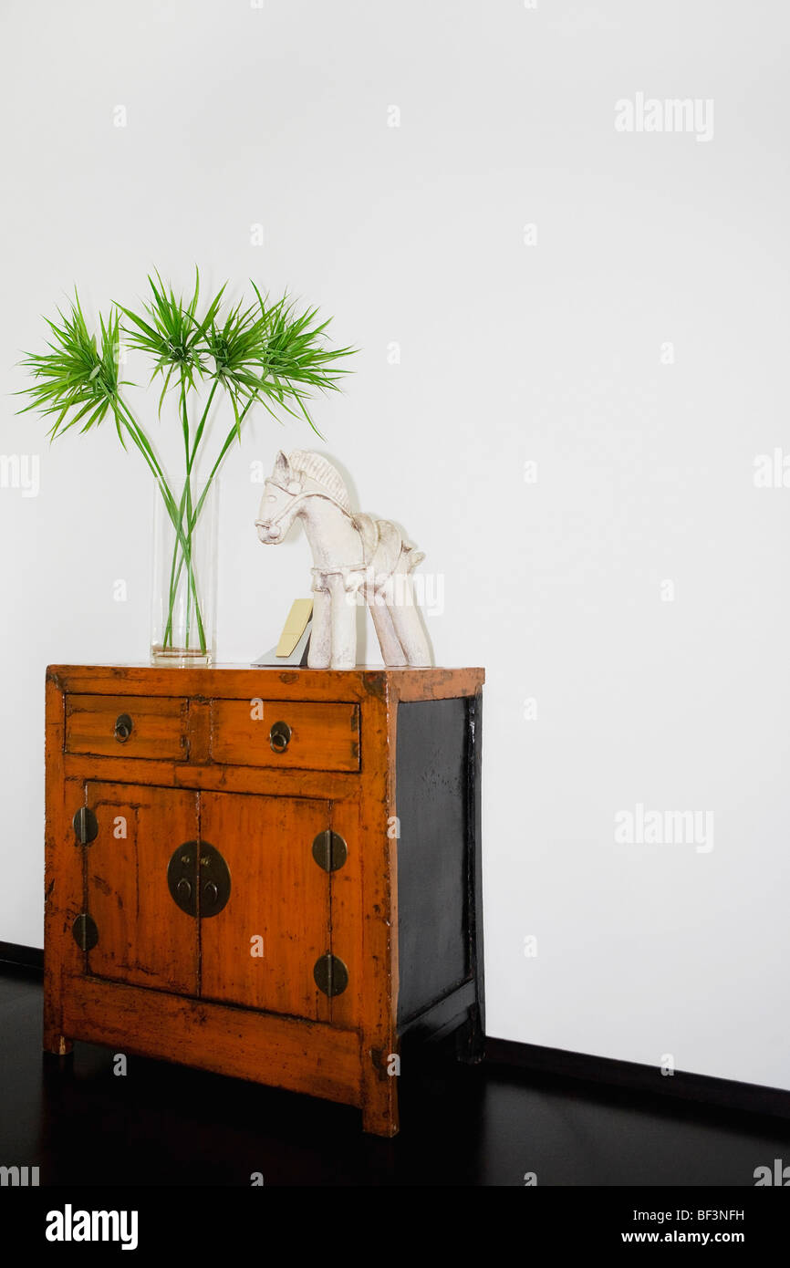 Vase and figurine on a wooden cabinet Stock Photo